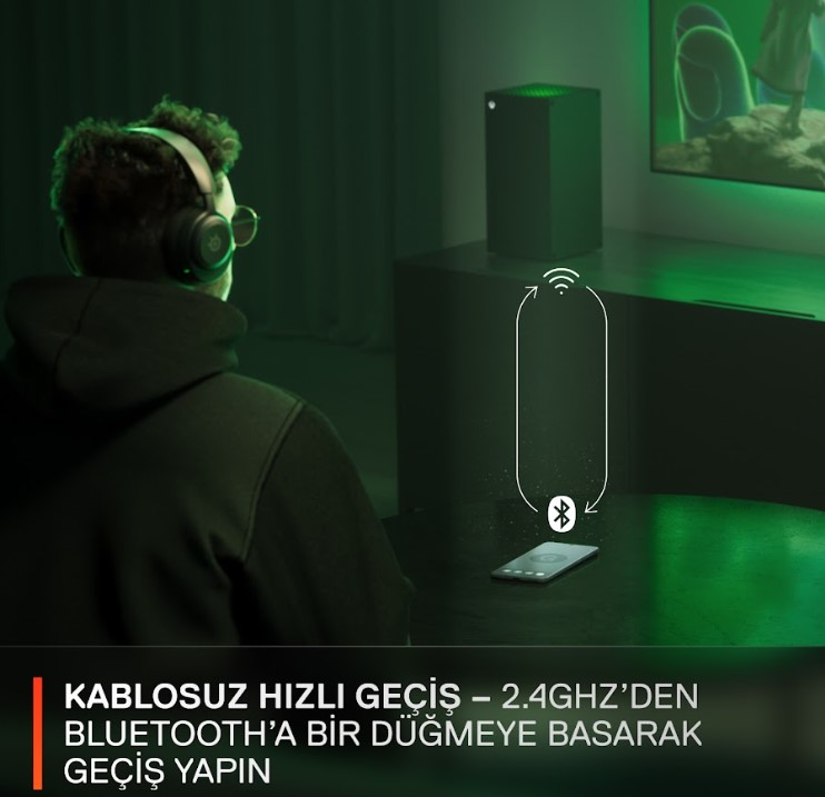 Kulaklıklı bir kişi, Bluetooth aracılığıyla telefon ve oyun konsoluna bağlanıyor.