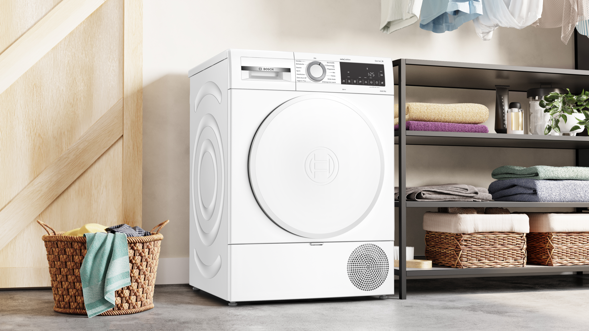 Ein weißer Bosch-Trockner steht neben einem Regal mit Handtüchern und Pflanzen. Ein Wäschekorb mit Kleidung steht vor einer Holztür.
