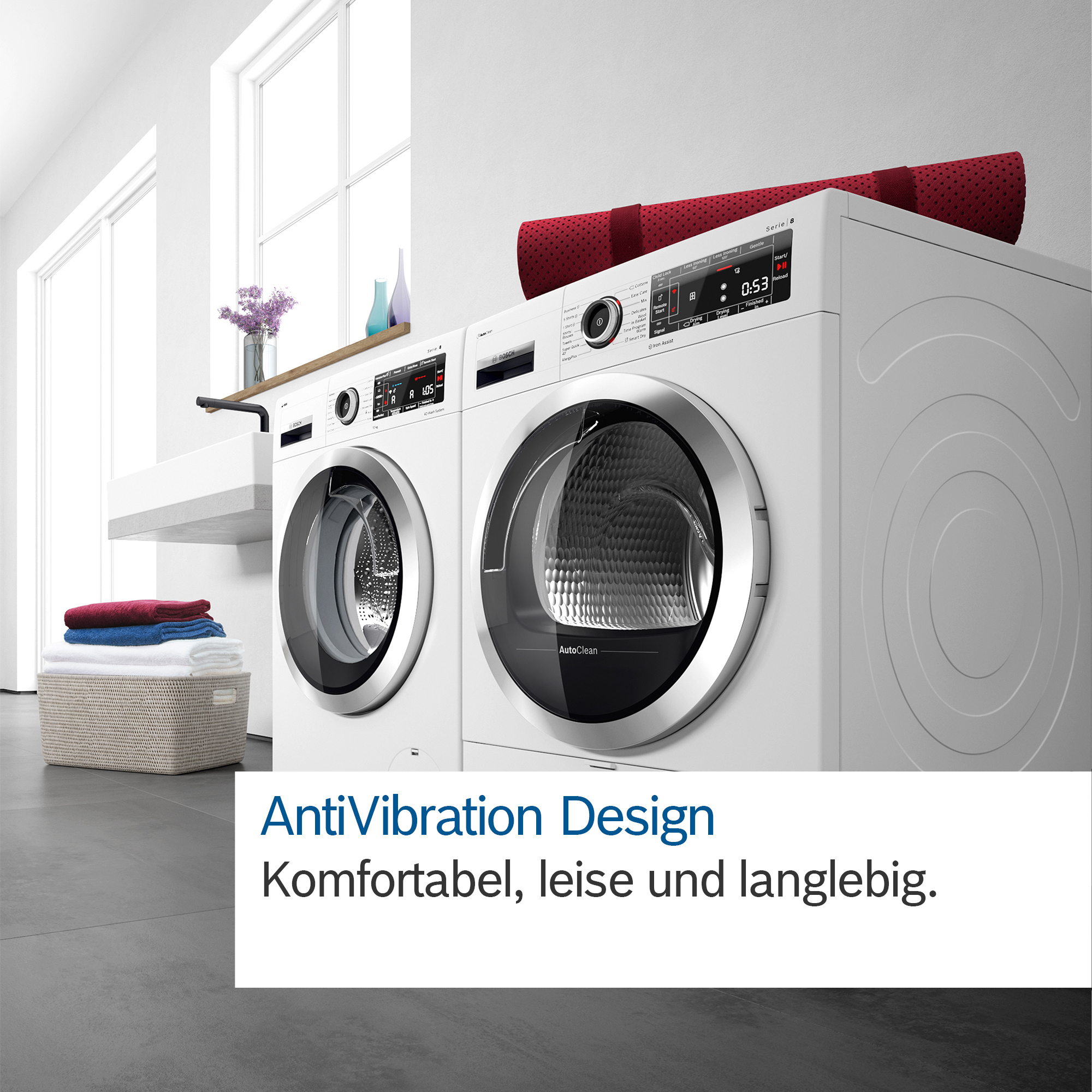 Zwei weiße Waschmaschinen, rote Matte oben. Korb mit Handtüchern im Vordergrund. Text: AntiVibration Design.