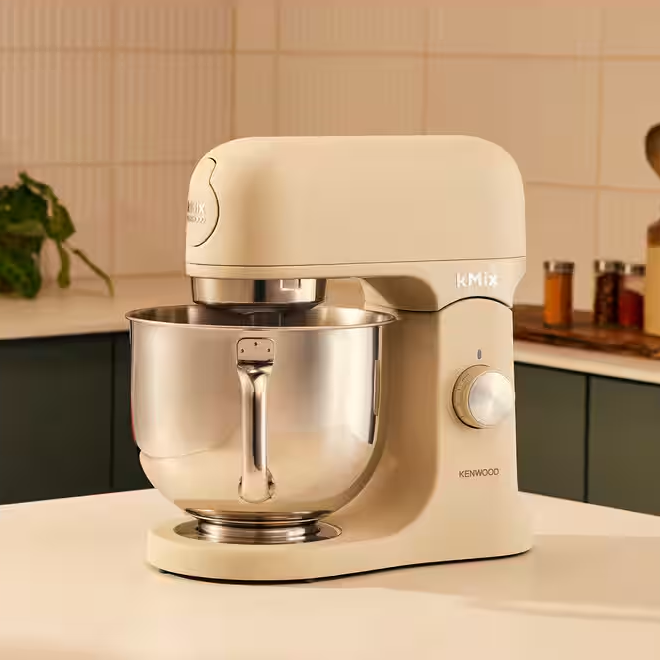 Bézs KitchenAid robotgép, rozsdamentes acél tál, fehér pulton. Kenwood márka.