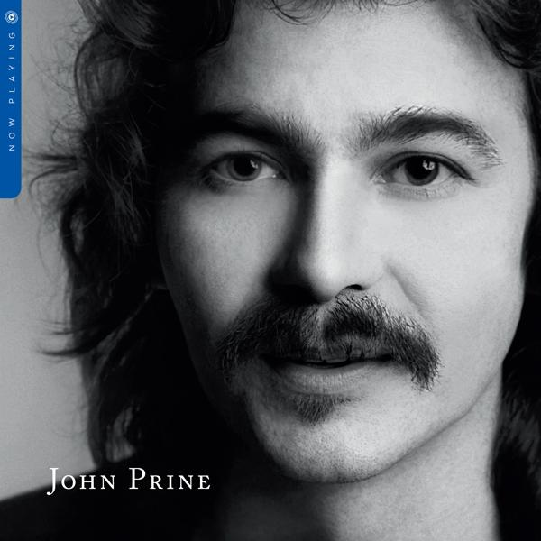 Nahaufnahme von John Prine. Er hat einen Schnurrbart, dunkles Haar und schaut in die Kamera.
