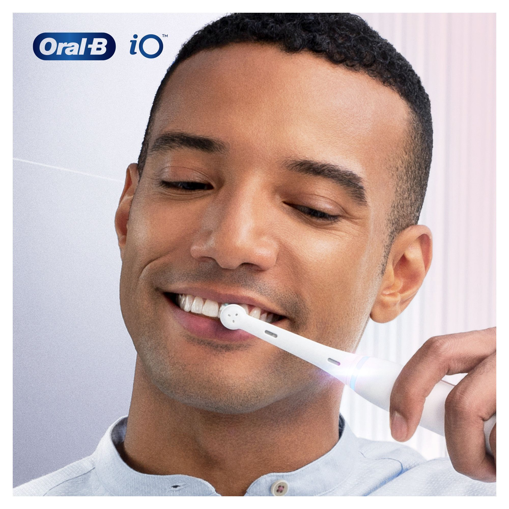 Ein lächelnder Mann putzt sich mit einer elektrischen Zahnbürste Oral-B iO die Zähne.