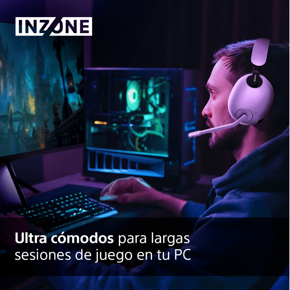 Persona con auriculares, jugando en PC, habitación oscura, monitor y teclado negro.