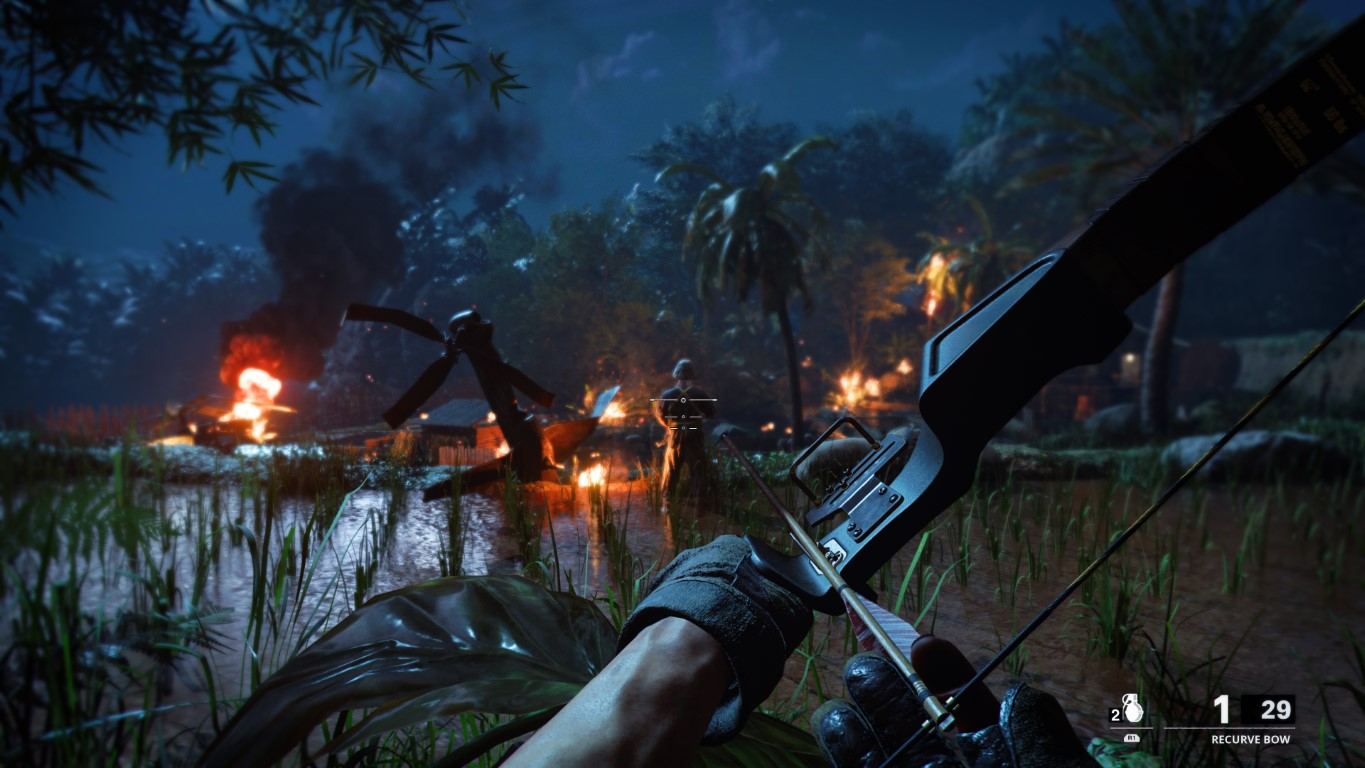 Widok z perspektywy pierwszej osoby łuku celującego w płonącą scenę w dżungli nocą.