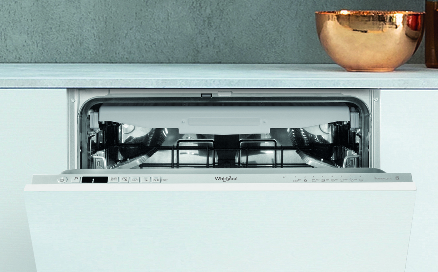 Un lavavajillas Whirlpool blanco abierto con platos, en un entorno de cocina blanco.