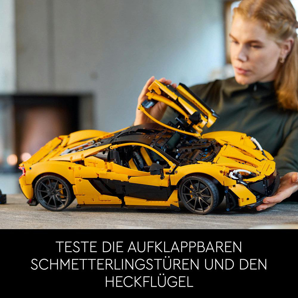 Gelber Lego-Sportwagen mit schwarzen Akzenten, Hände einer Frau halten ein Autoteil.