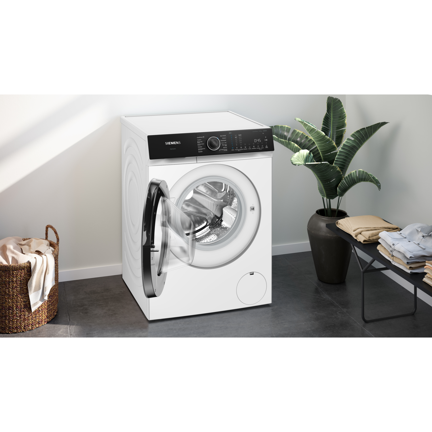 White washing machine with open door next to a wicker basket and a plant.