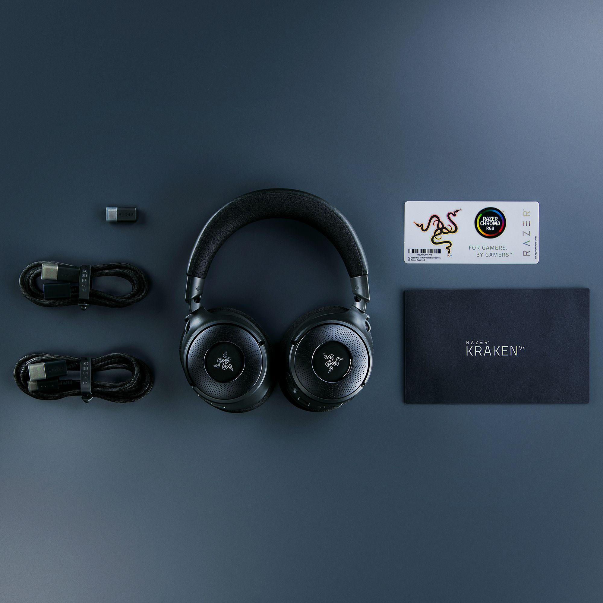 Schwarze Gaming-Kopfhörer, Kabel und Zubehör ordentlich auf dunkler blauer Oberfläche angeordnet.