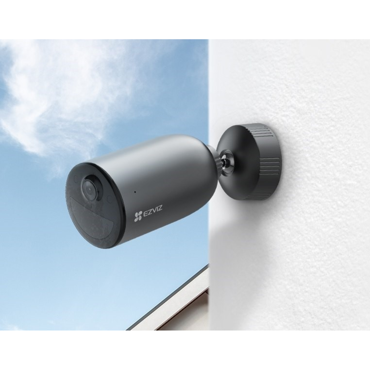 Outdoor security camera mounted on a white wall, with a blue sky background.