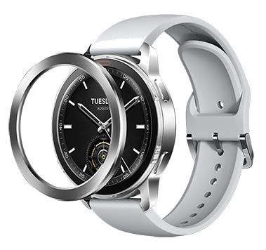 Srebrny smartwatch z czarną tarczą, białym paskiem i odłączonym srebrnym pierścieniem.