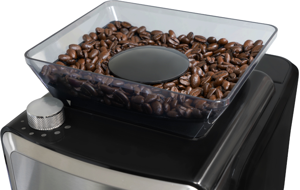 Coffee beans in a clear container on a coffee machine.