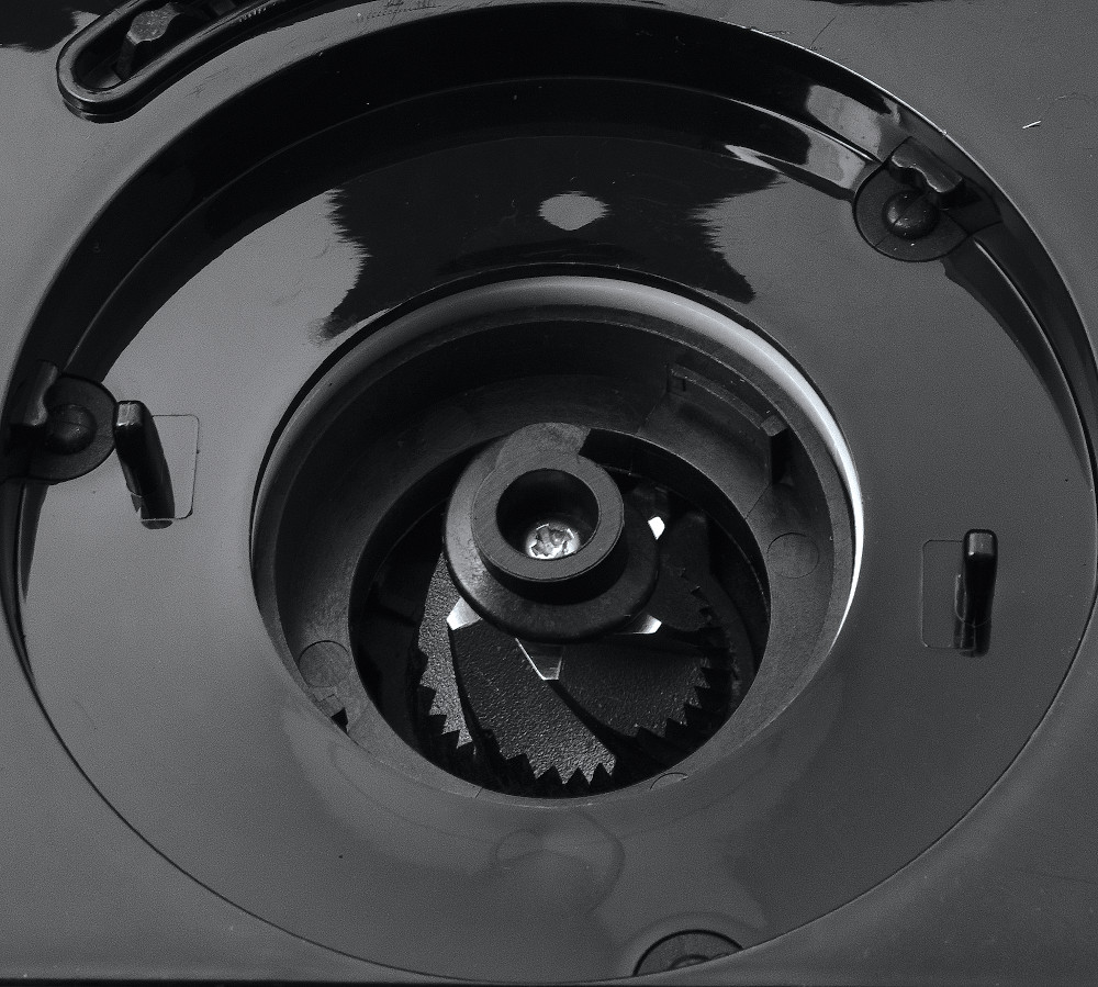 Close-up of a black coffee grinder's grinding mechanism.
