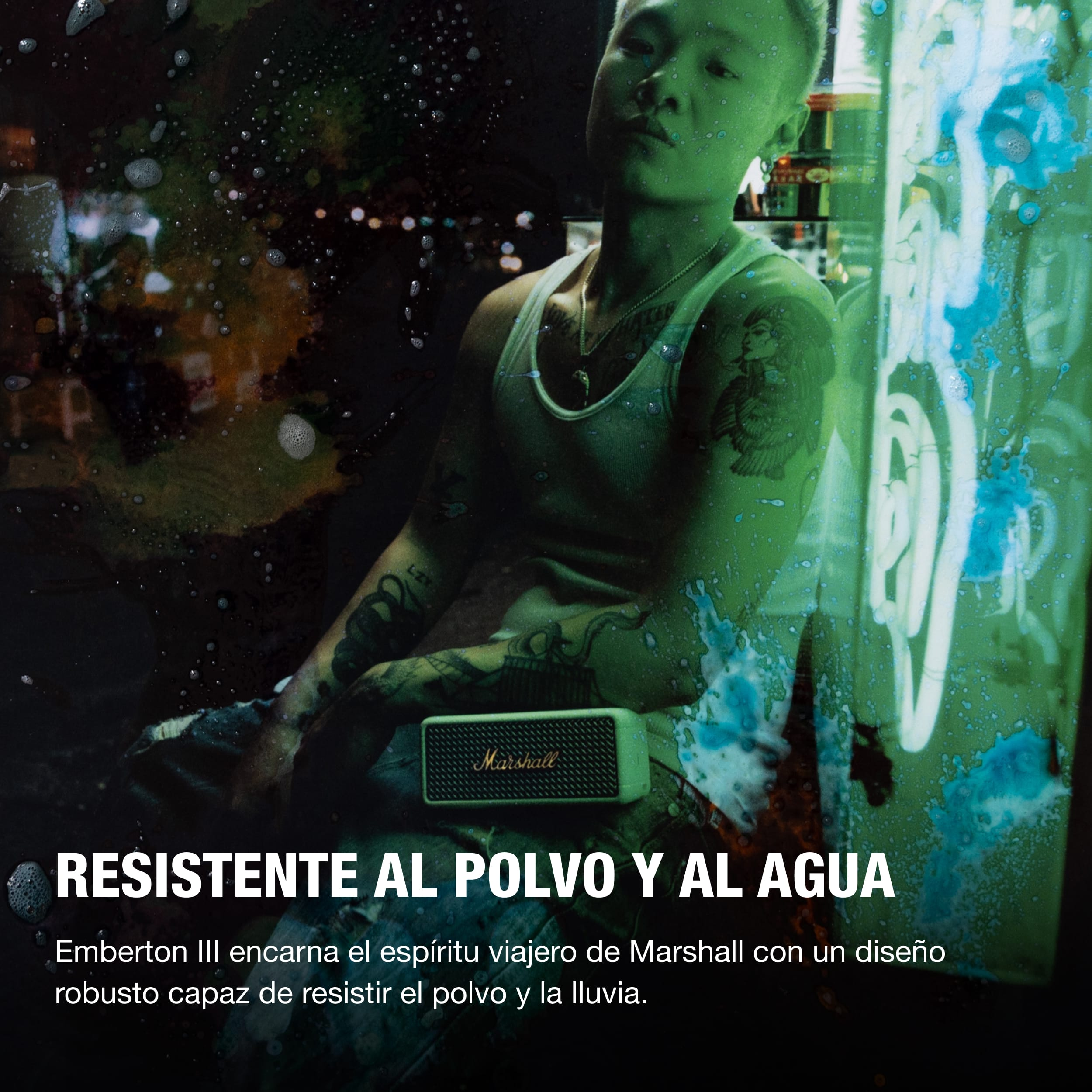 Hombre tatuado con altavoz Marshall, gotas de agua, fondo de grafiti.