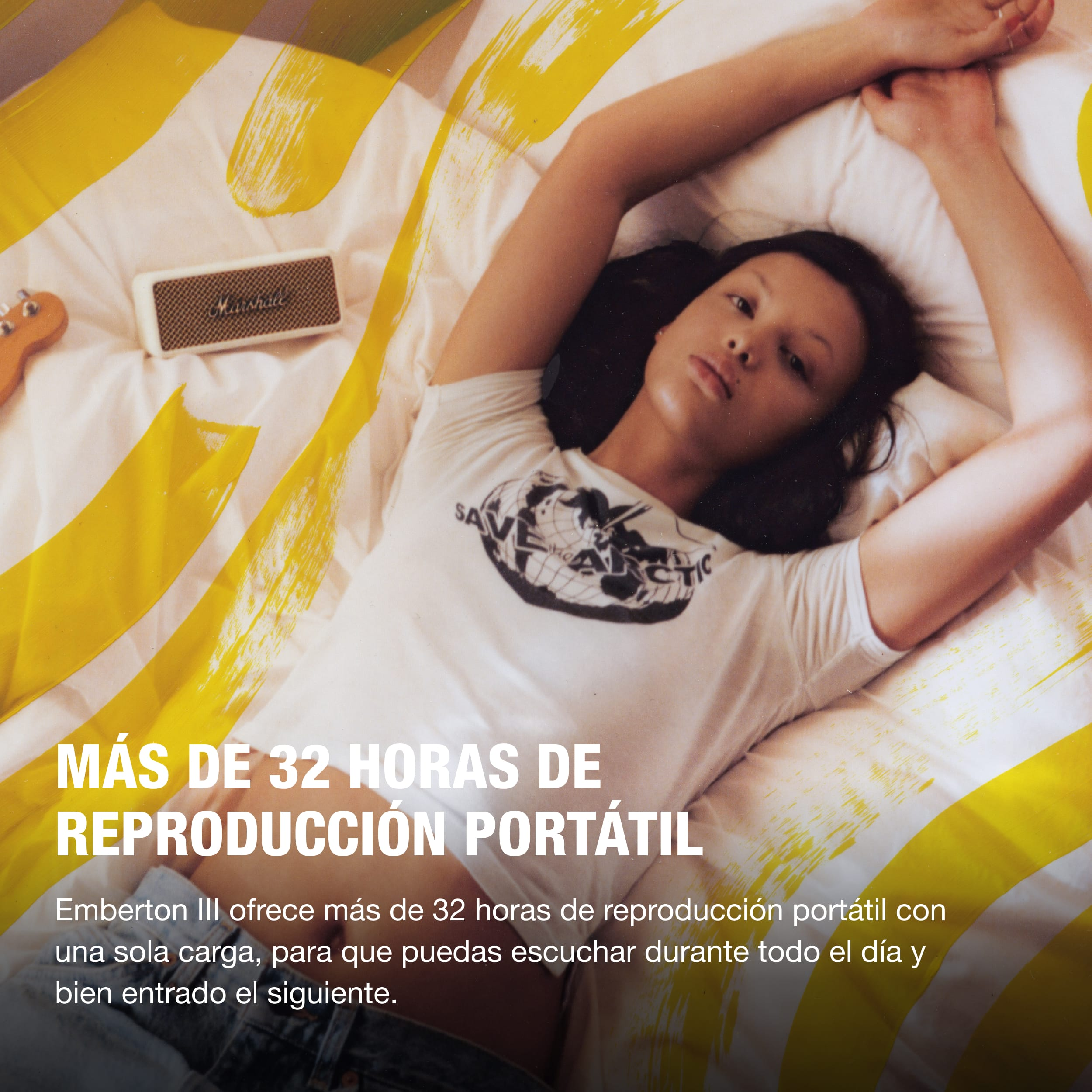 Una mujer acostada en una cama con una camisa blanca, junto a un altavoz y pinceladas amarillas.