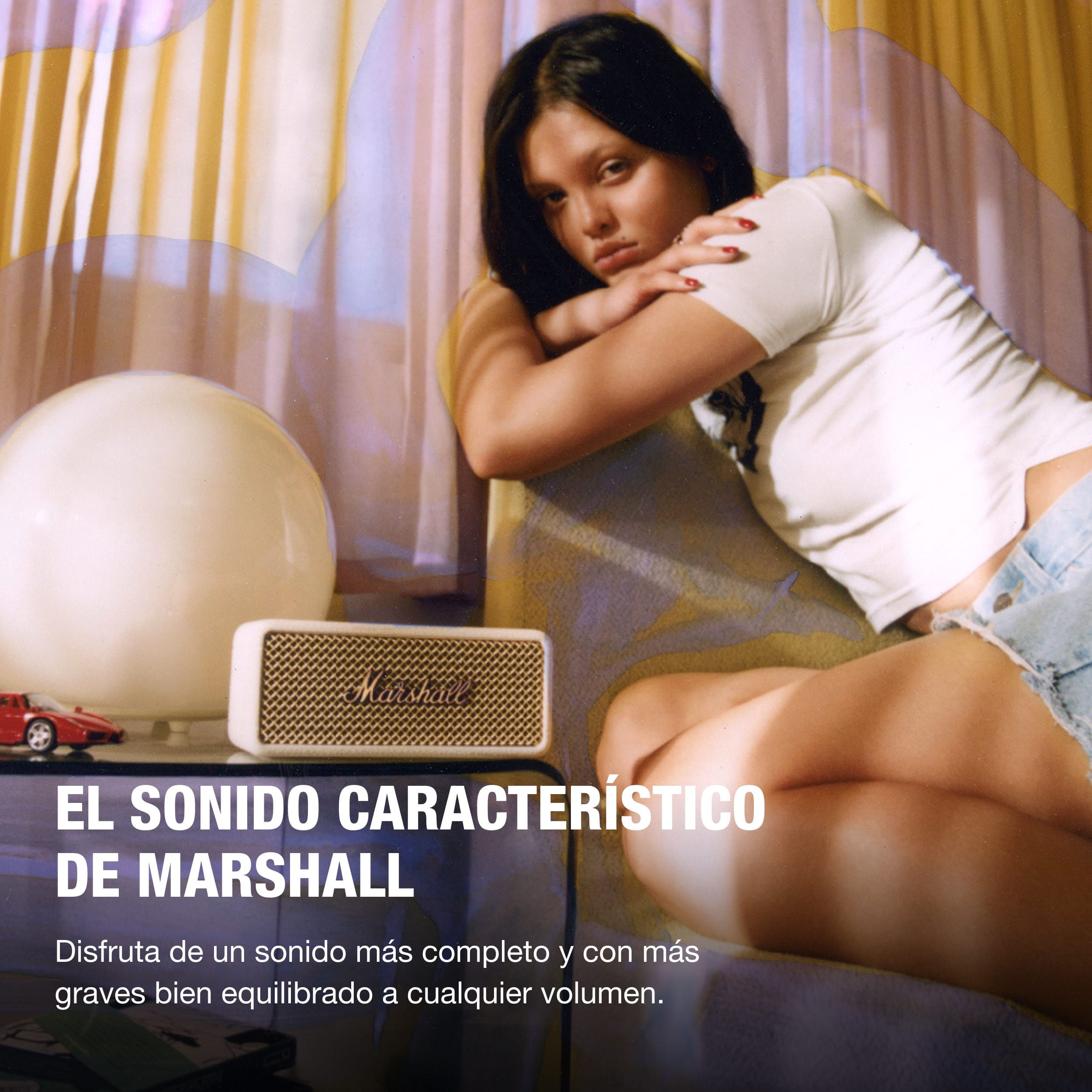 Una mujer con cabello oscuro sentada cerca de un altavoz con texto en español.