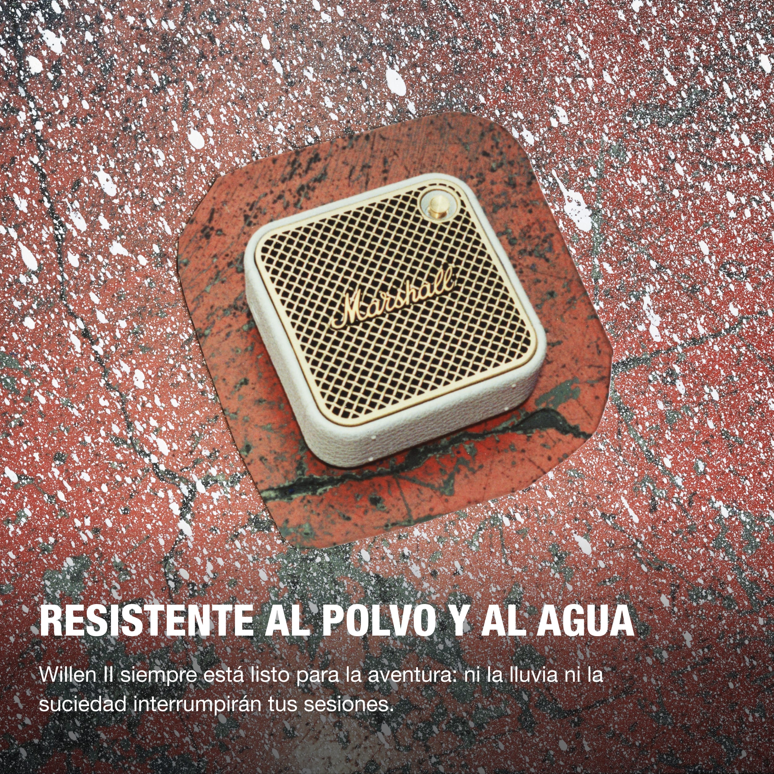 Un altavoz blanco y dorado sobre una superficie roja. El texto dice que es resistente al polvo y al agua.