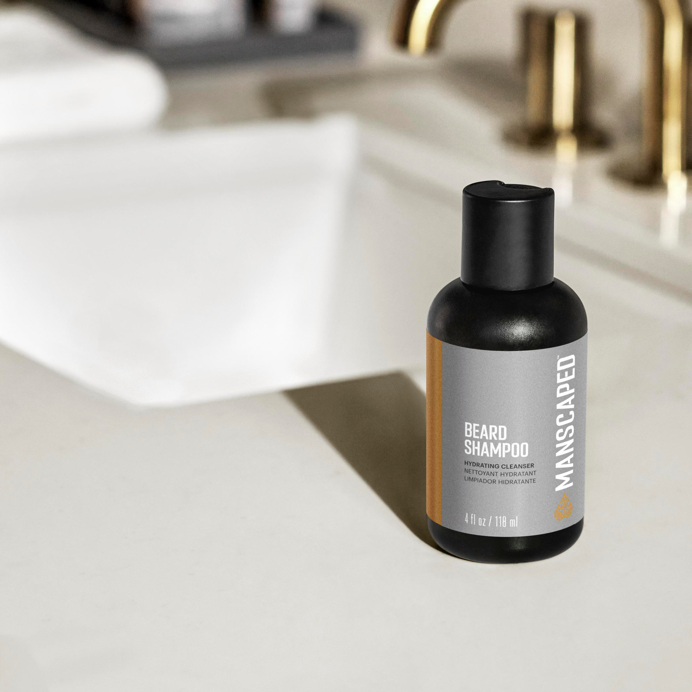 Eine schwarze Bartshampoo-Flasche auf einer weißen Arbeitsplatte, im Hintergrund das Waschbecken.