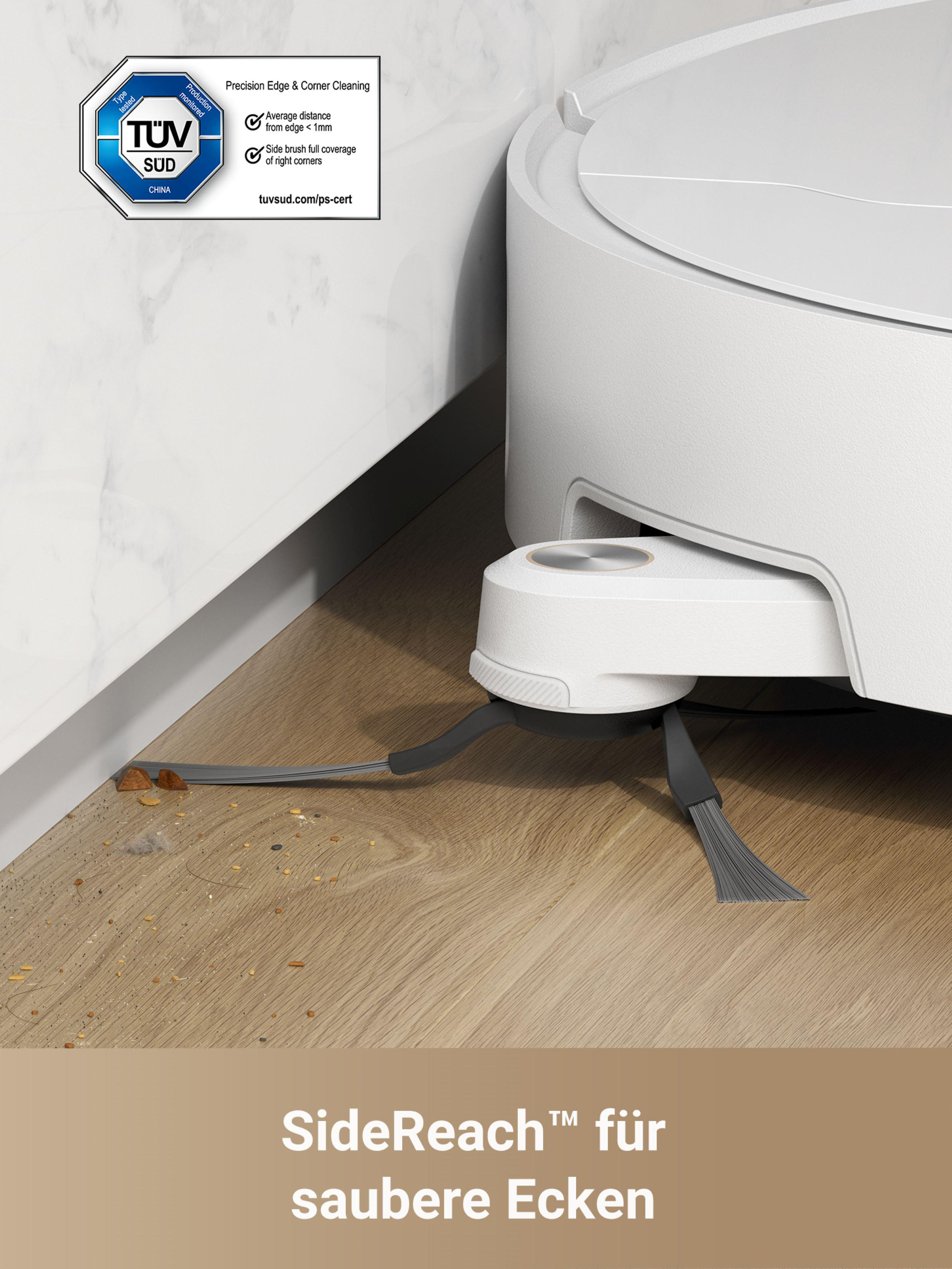 Der Roboter-Staubsauger mit Seitenbürsten reinigt in der Nähe einer weißen Wand.