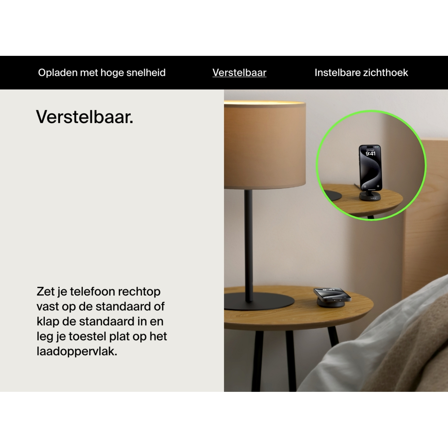 Telefoonopstelling: telefoon op standaard, oplaadpad en lamp op houten tafel. Lichte achtergrond.