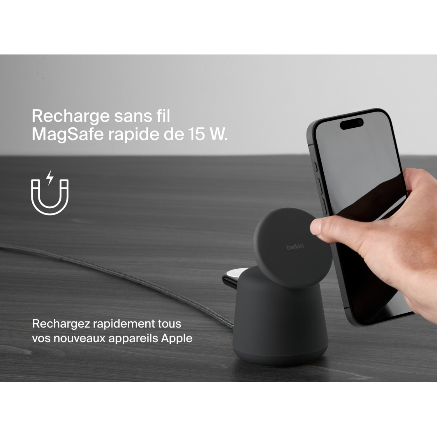 Main place un téléphone sur un chargeur sans fil Belkin, texte sur charge rapide MagSafe.
