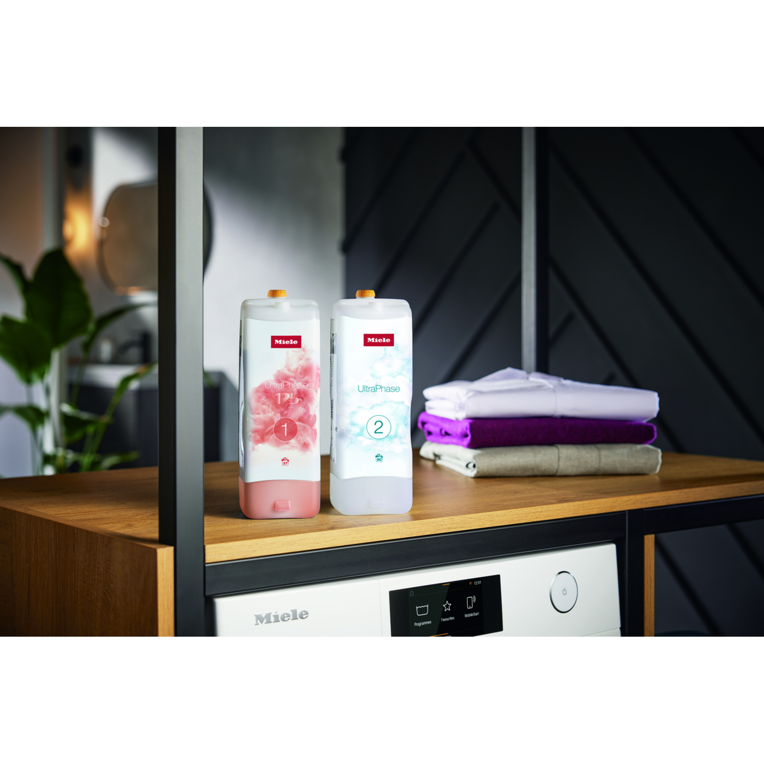Deux bouteilles de détergent blanc à côté d'une machine à laver. Pile de vêtements.