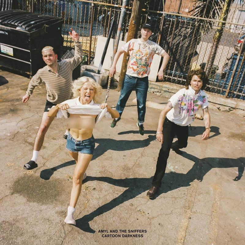 Band Amyl and The Sniffers, draußen. Vier Personen: einer mit Zunge raus, einer springt, andere posieren.