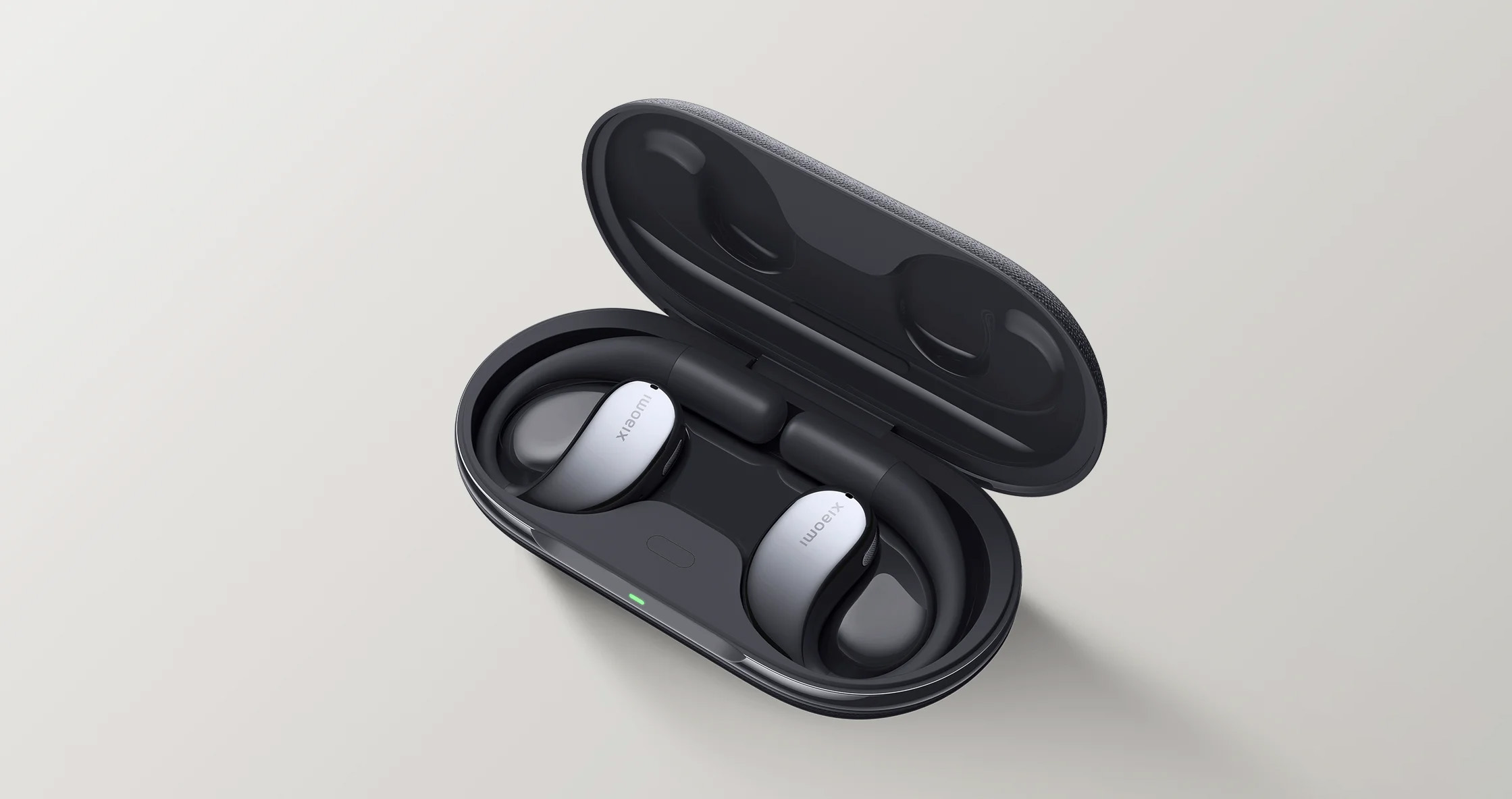 Słuchawki douszne w etui ładującym. Białe i srebrne słuchawki. Etui otwarte.