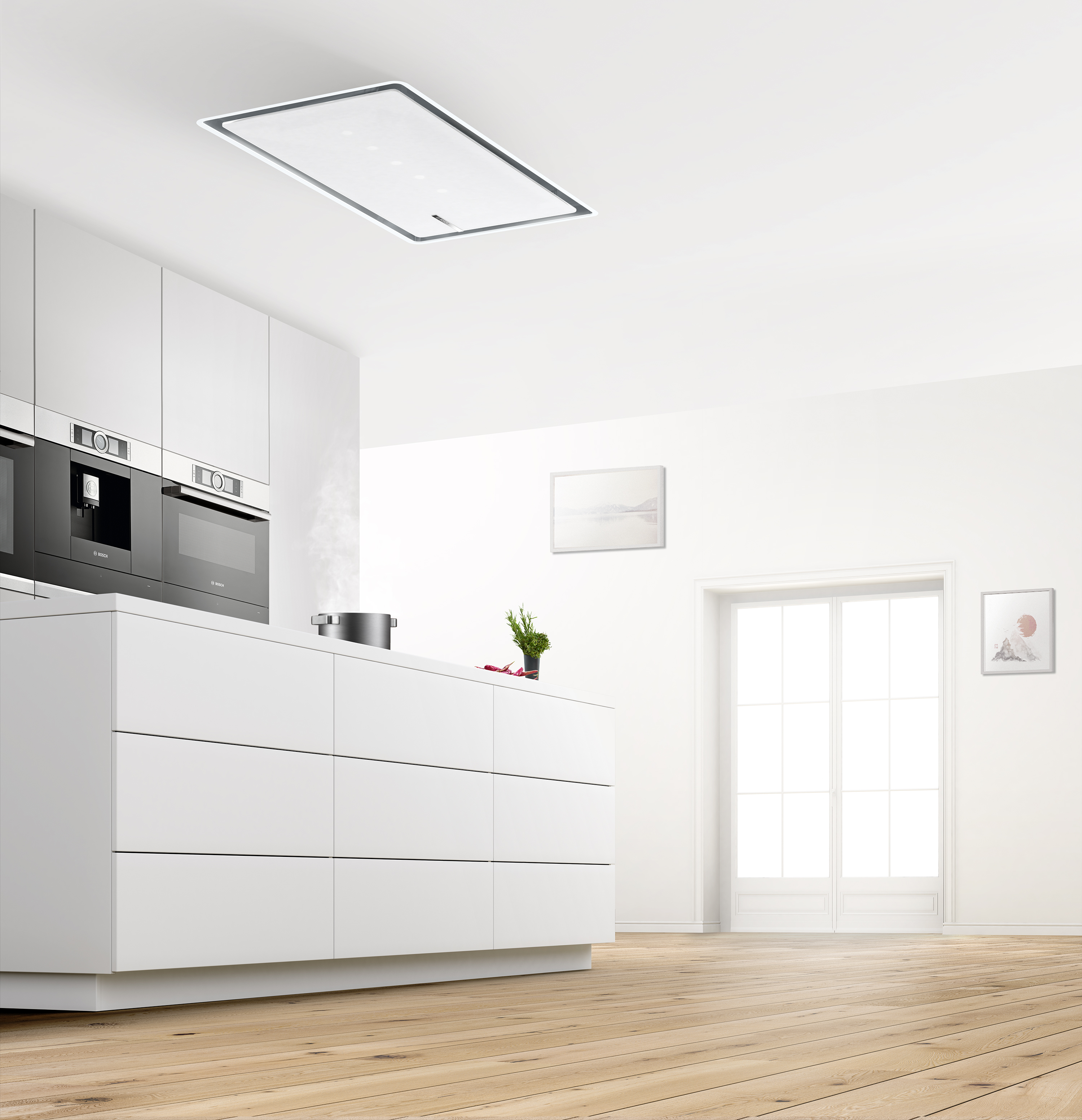 Cocina blanca moderna con isla blanca, electrodomésticos negros empotrados y campana de techo.