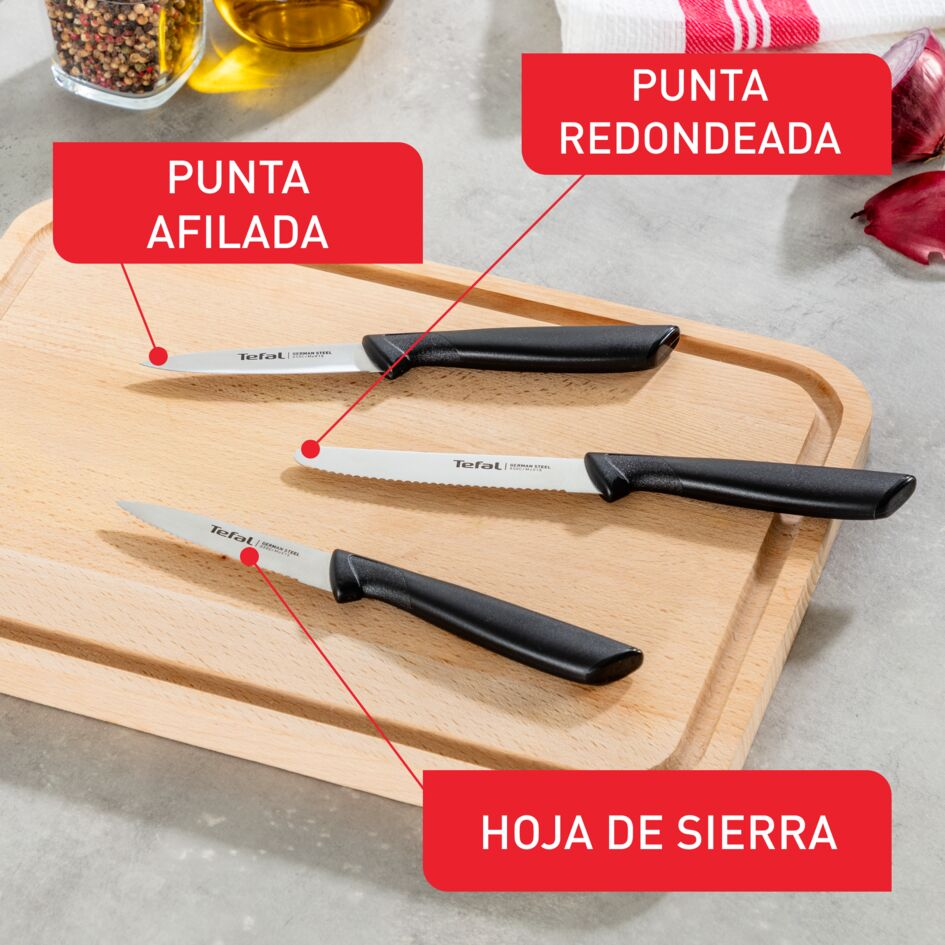 Tres cuchillos en una tabla de cortar. Puntas afiladas, dentadas y redondeadas. Etiquetas rojas.