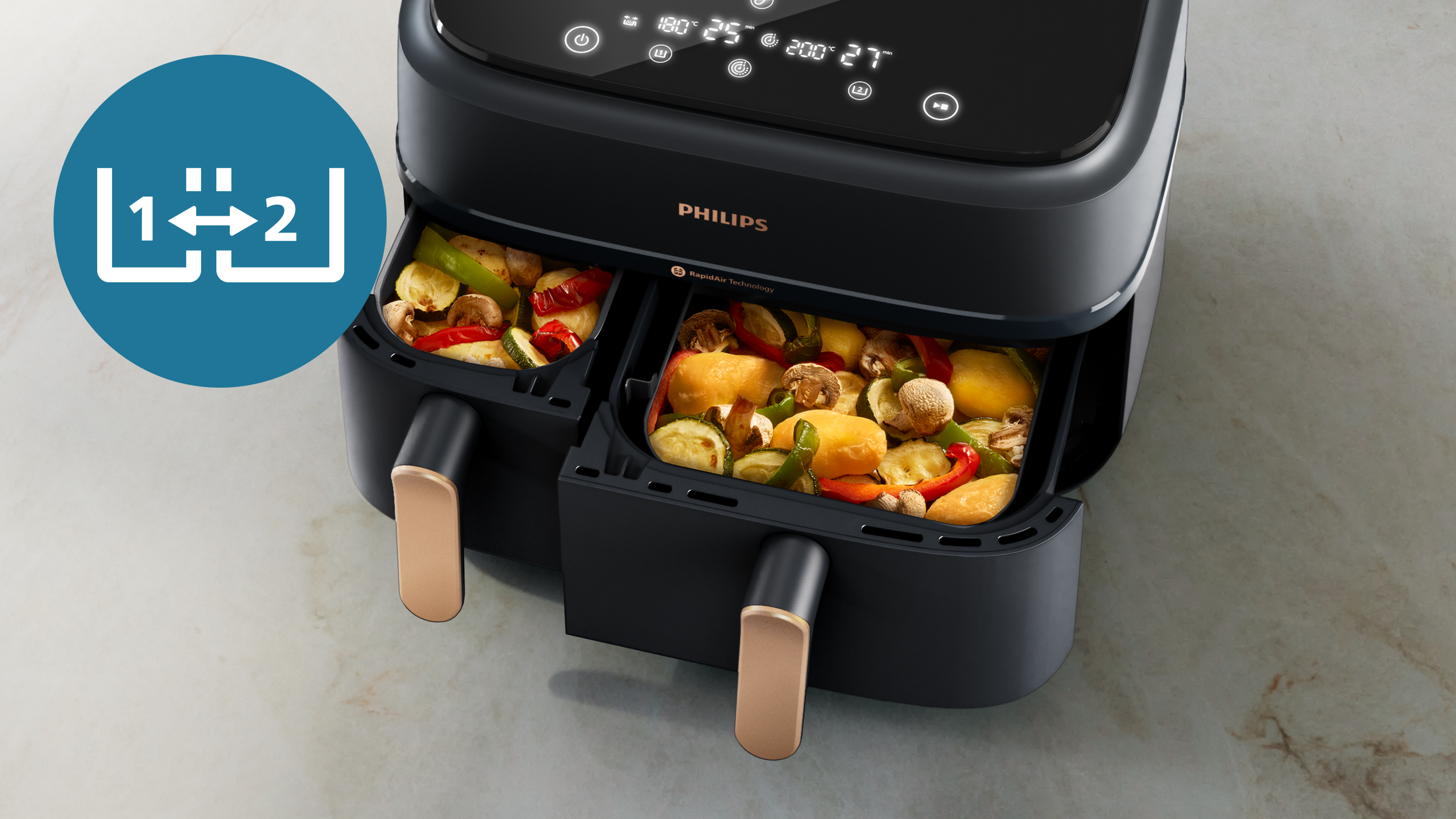 Friggitrice ad aria Philips nera con due scomparti contenenti verdure cotte.