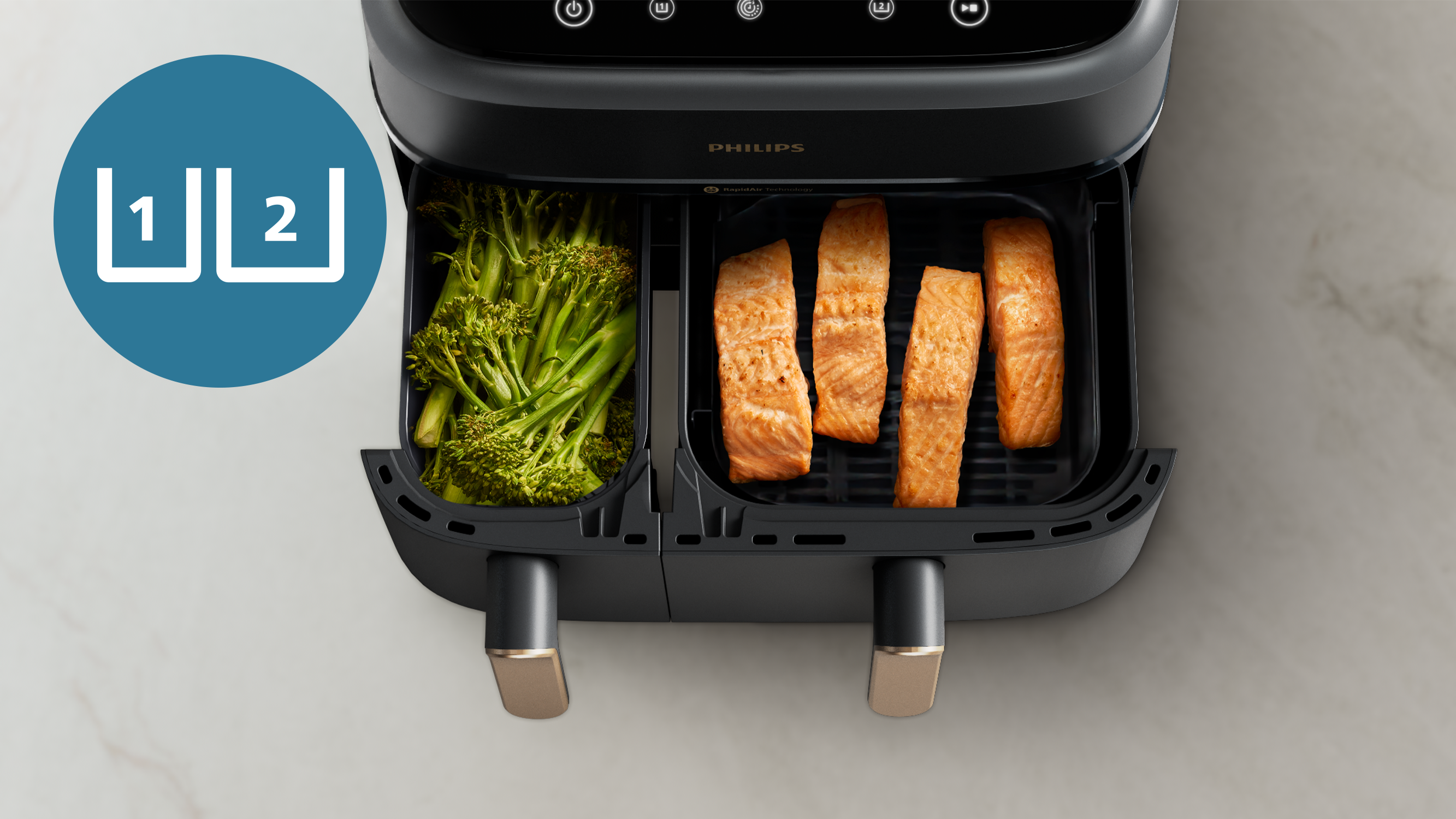Una friggitrice ad aria con due cestelli. Uno con broccoli, l'altro con pezzi di salmone.