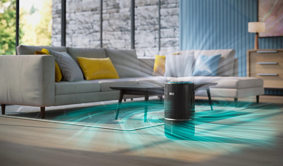 Oczyszczacz powietrza na dywanie, z sofą i oknem w tle. Efekt wirowania powietrza.