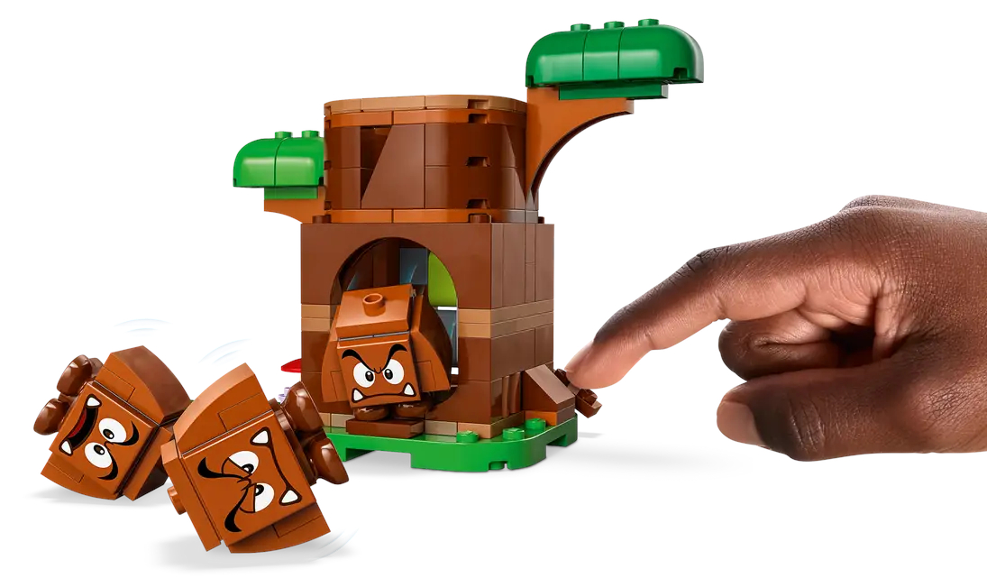 Zestaw Lego z figurkami Goomby i drzewem, z ręką wchodzącą w interakcję.