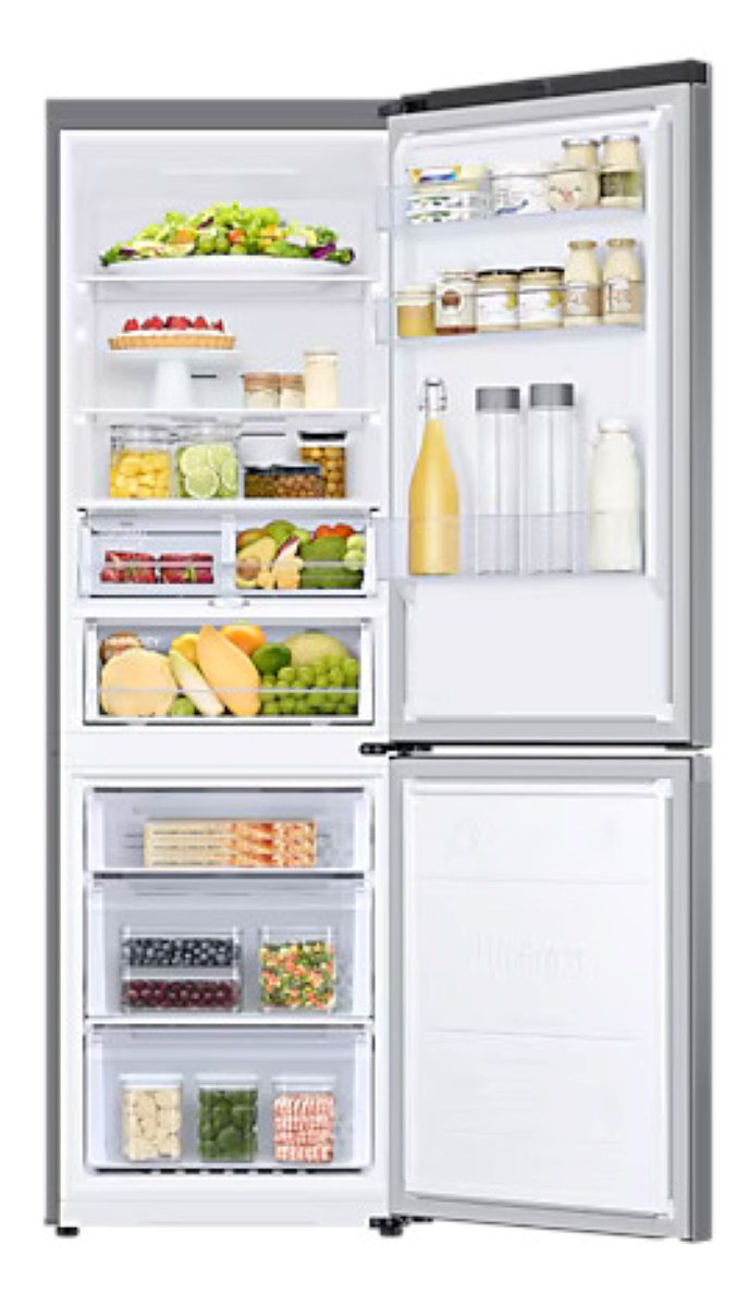 Lodówka z otwartymi drzwiami, wypełniona produktami spożywczymi. Białe tło.