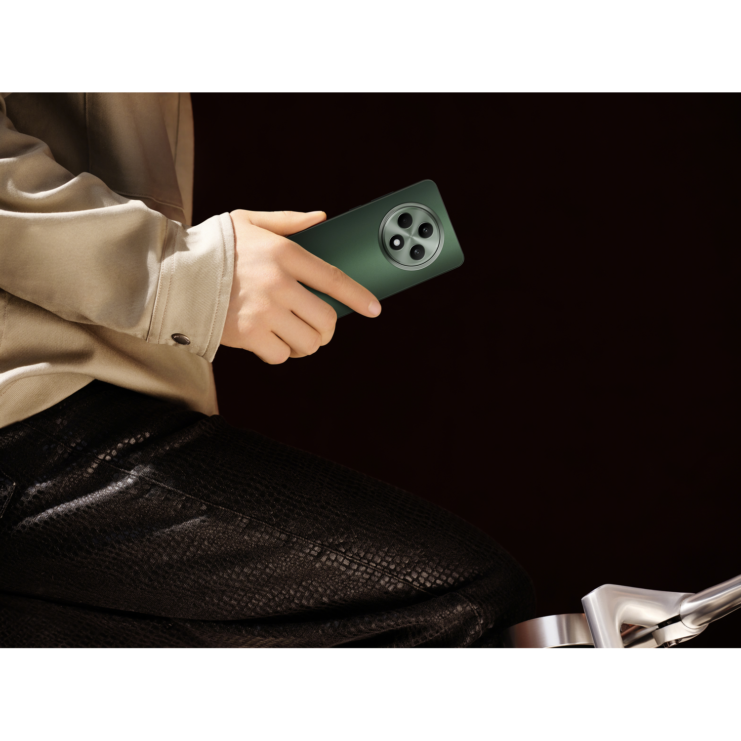 A person's hand holding a green smartphone. The background is black.