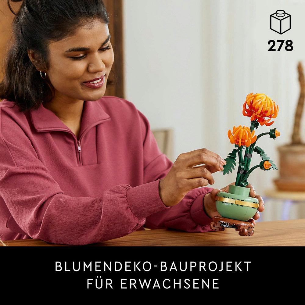 Frau mit Pflanze. Orangefarbene Blumen in einer grünen Vase auf einem Holztisch.