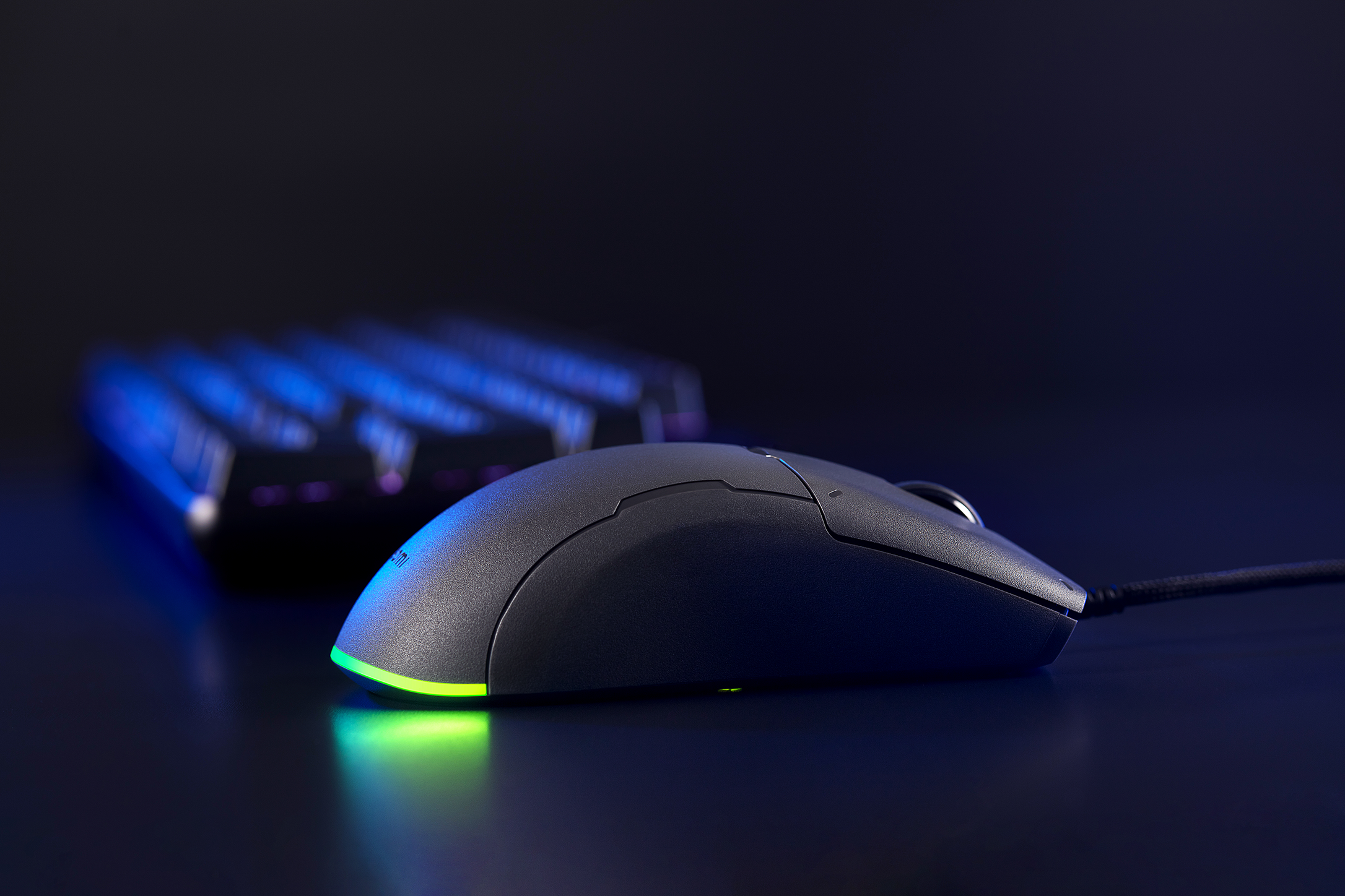 Fekete gamer egér RGB világítással, oldalnézet.