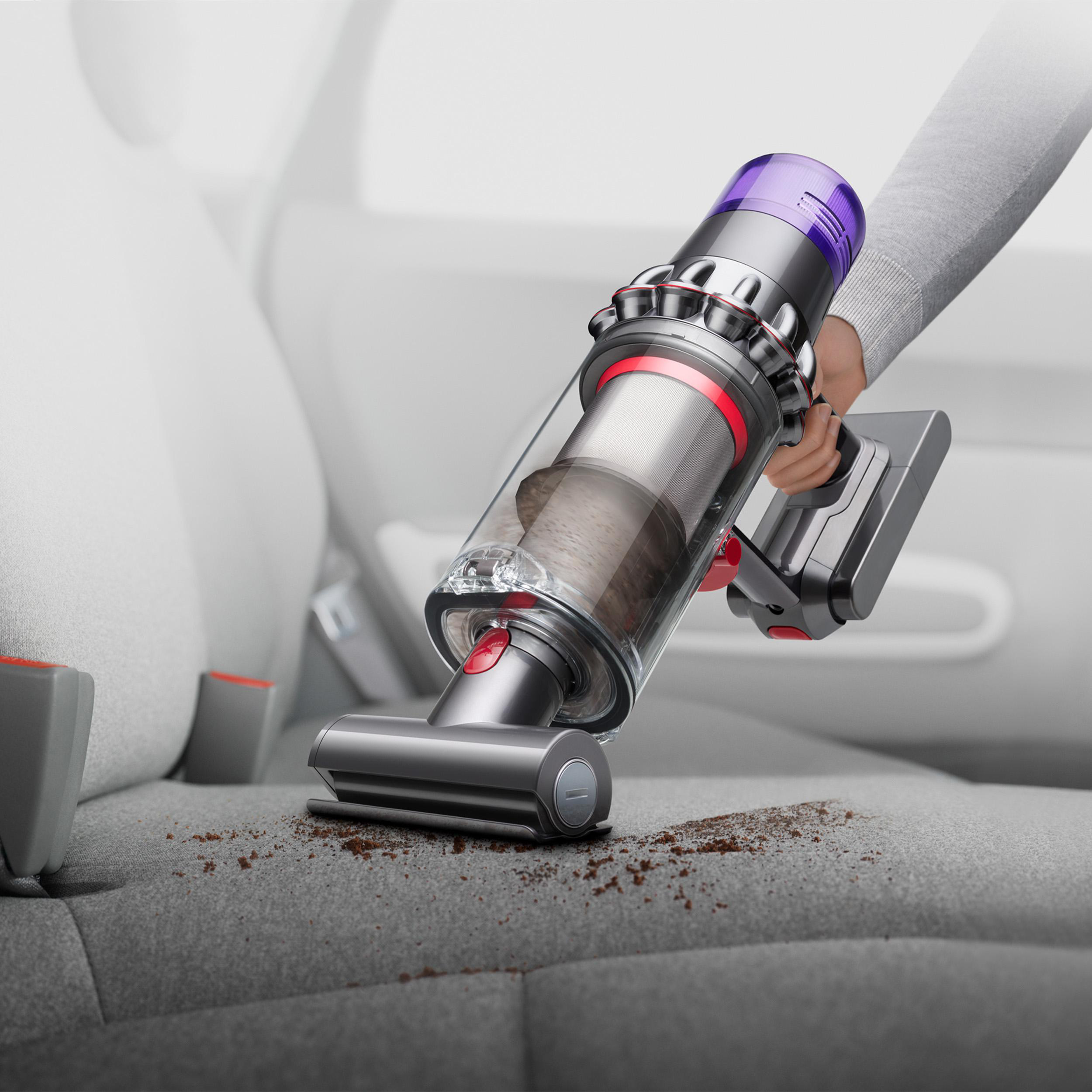 Staubsauger, der einen Autositz reinigt, mit Schmutz.