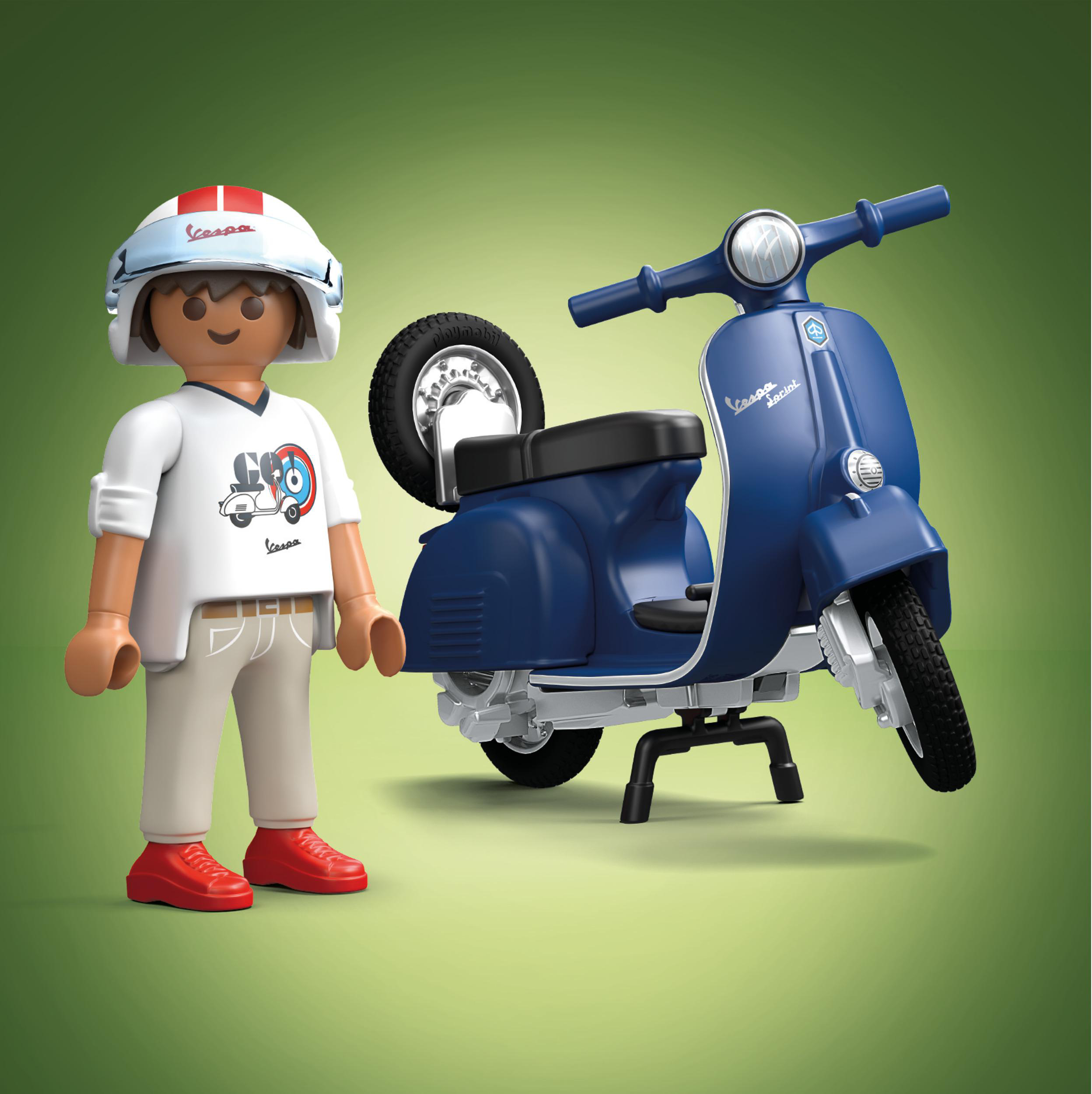 Spielzeug Vespa Roller und Fahrerfigur auf grünem Hintergrund.