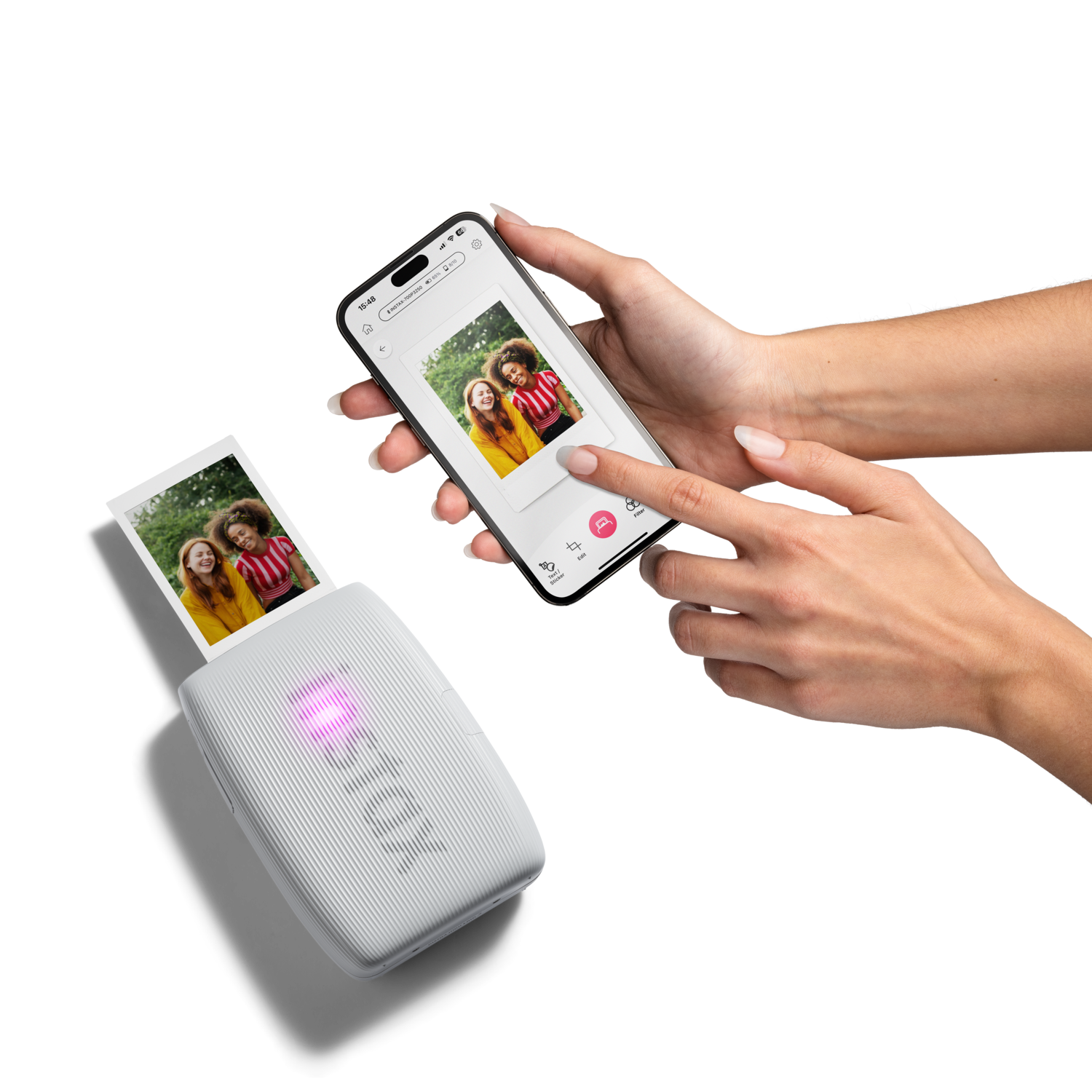 A white portable photo printer printing a photo, next to a smartphone displaying a photo.