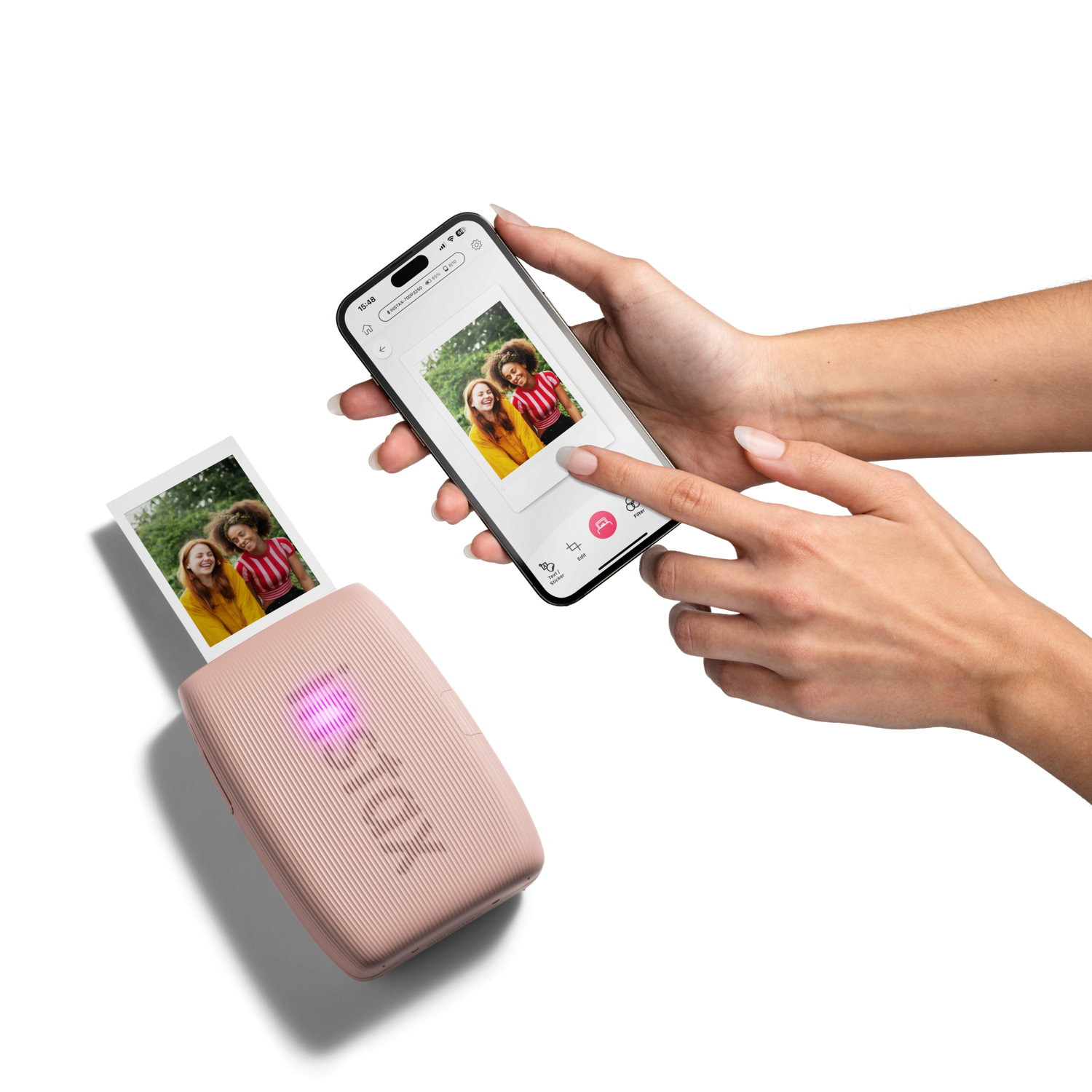 Woman printing photos from a phone. Pink Instax printer and photos on the left.