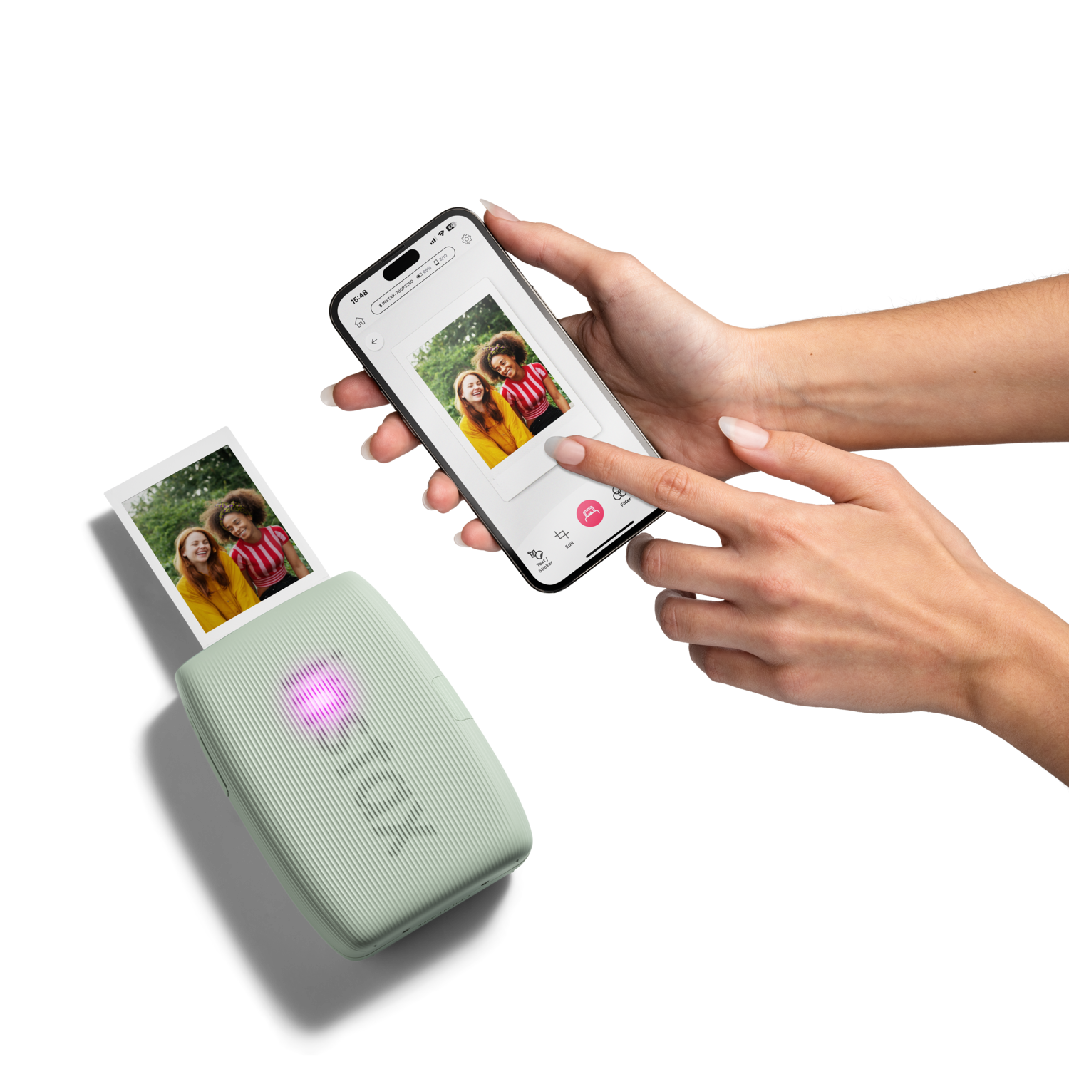 A woman using a portable photo printer. A printed photo and phone with image on screen are also visible.
