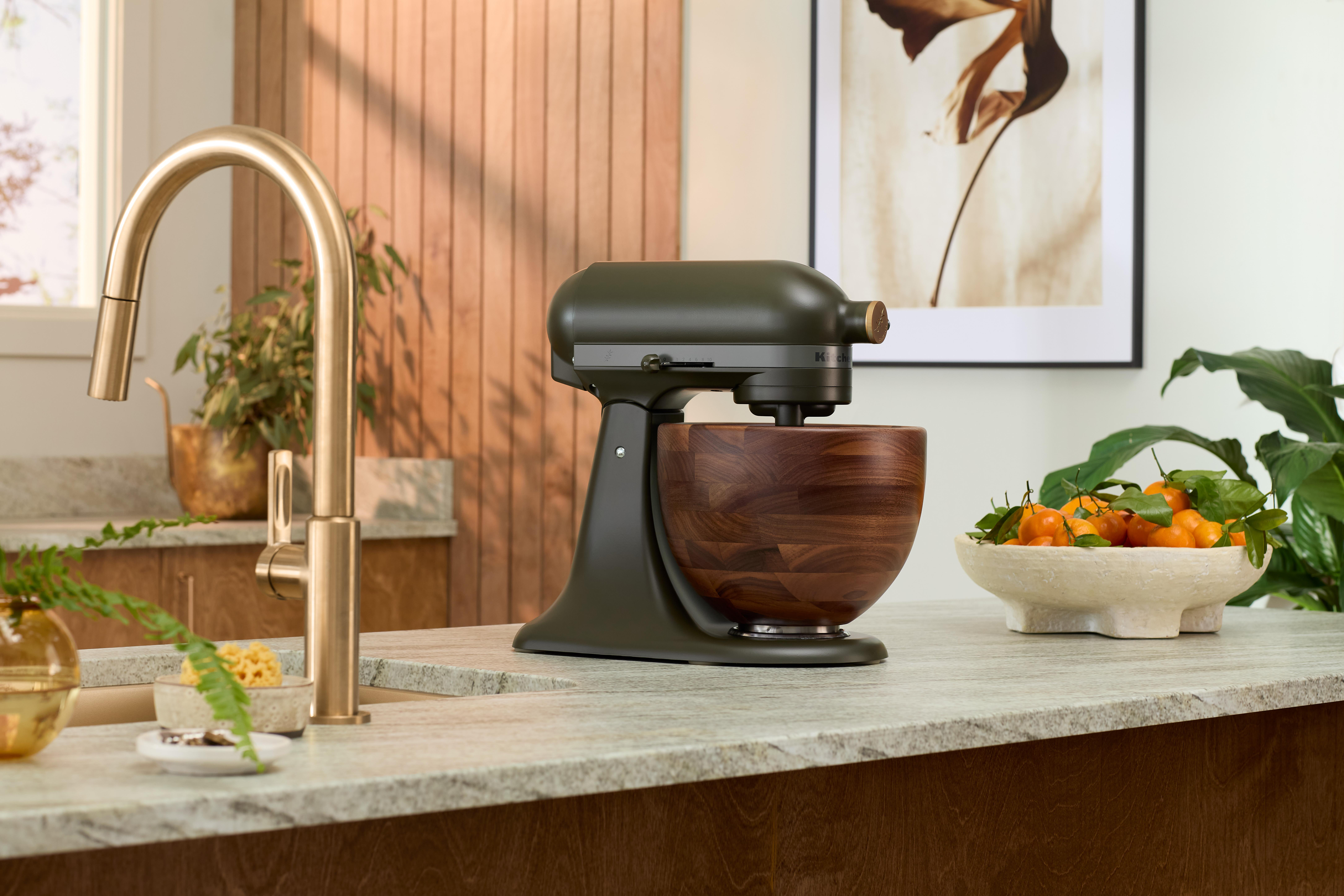 KitchenAid Küchenmaschine. Olivgrüner Körper, Holzschüssel. Küchenumgebung.