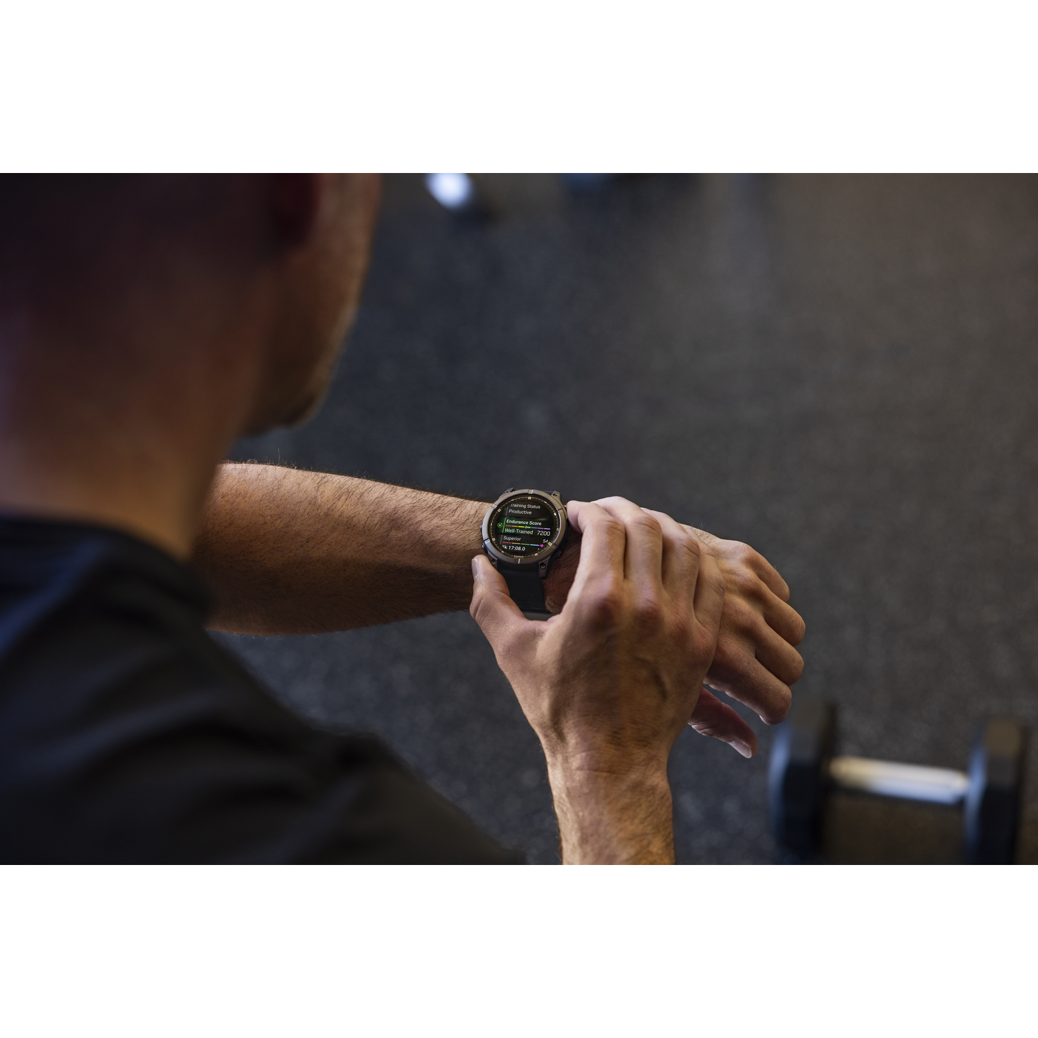 Man looking at a smartwatch displaying fitness data in a gym setting.