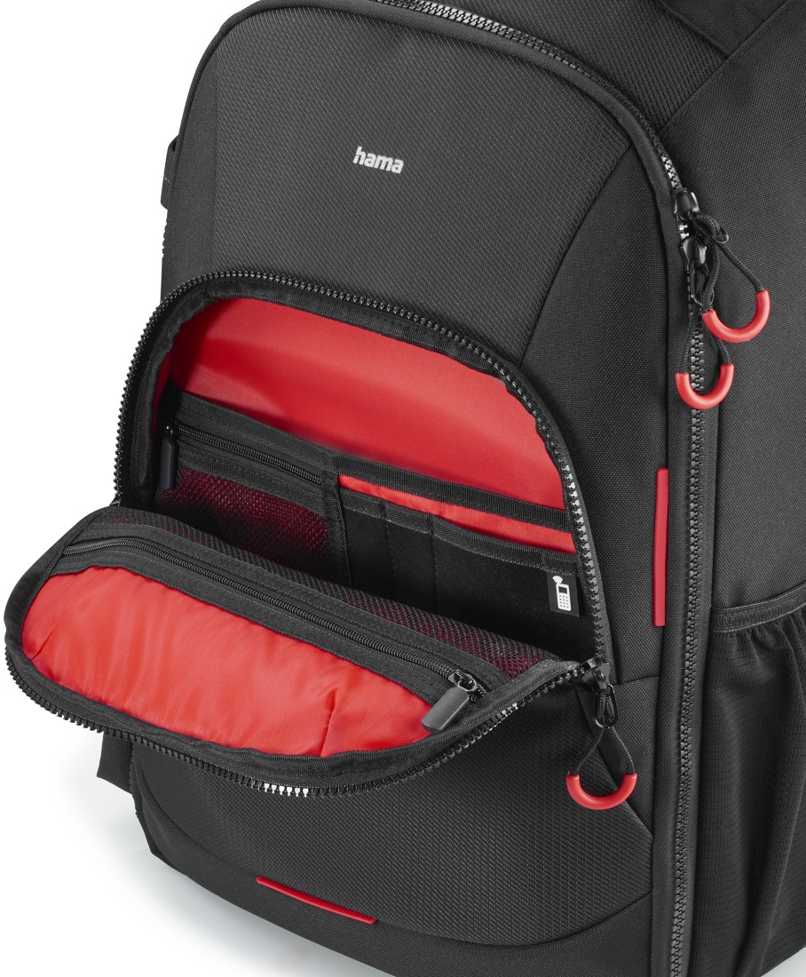 Offener schwarzer Rucksack mit rotem Innenraum. Zeigt mehrere Fächer und Reißverschlüsse.