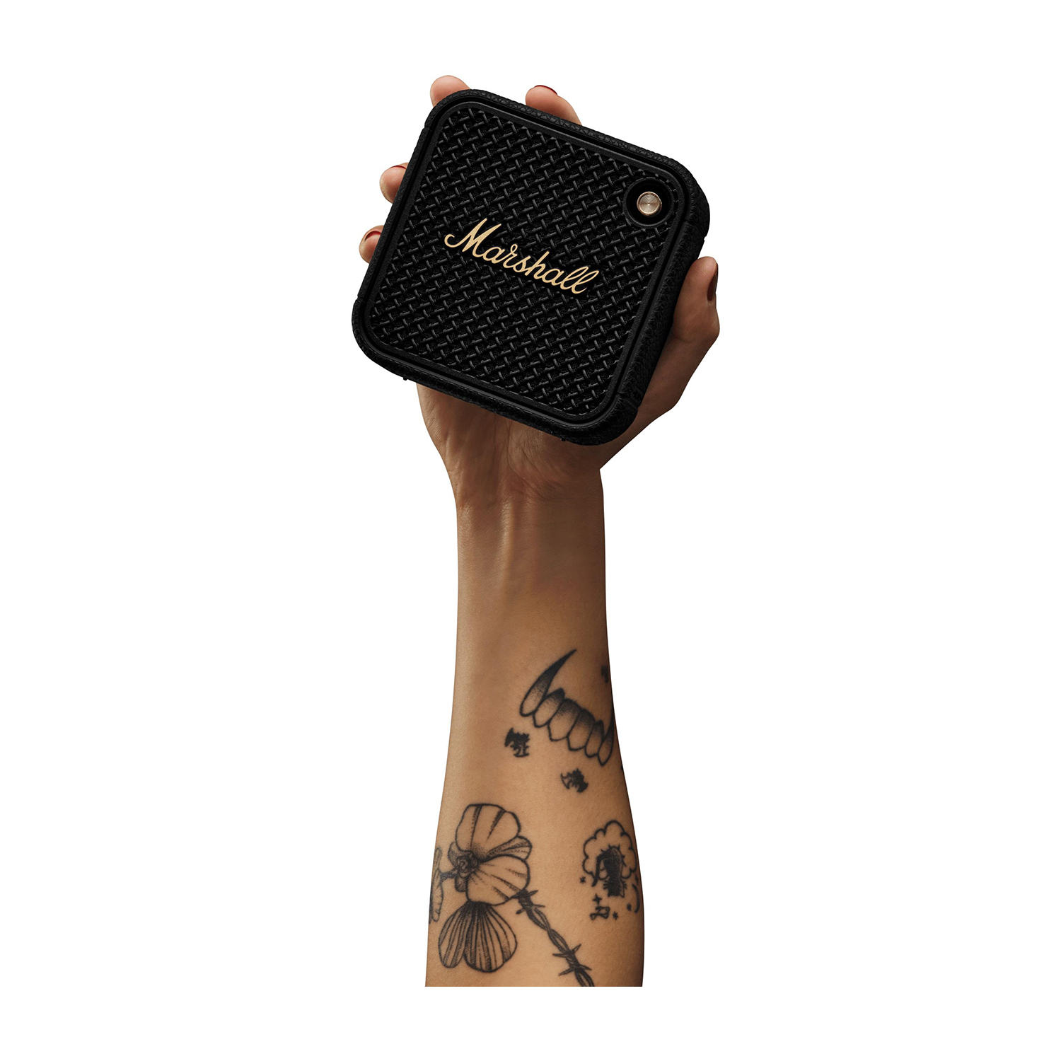 Mano che tiene un altoparlante Marshall nero, con un braccio tatuato visibile.