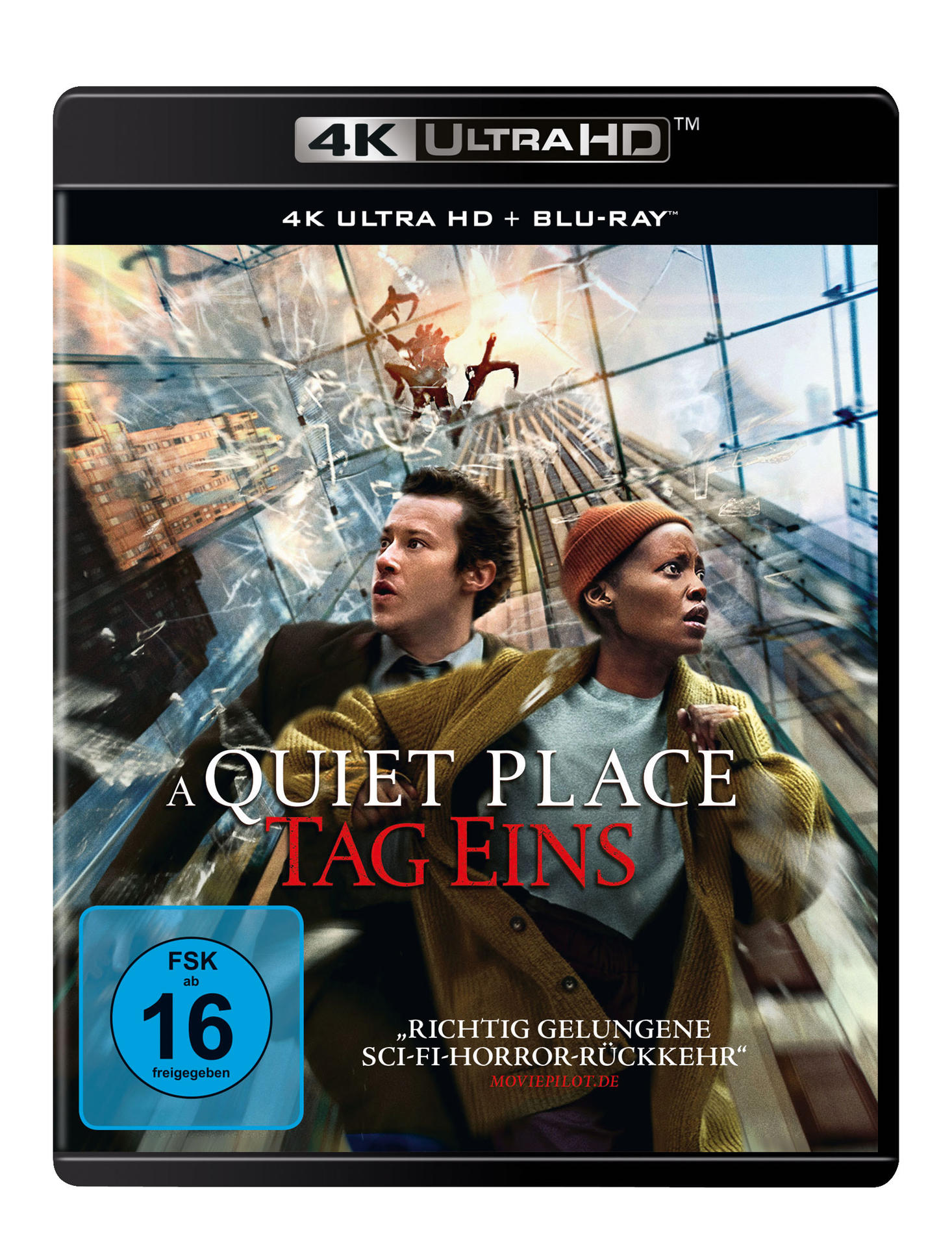Filmcover: A Quiet Place: Day One. Zwei Personen in einer Stadtszene mit beschädigten Gebäuden und stürzenden Menschen.
