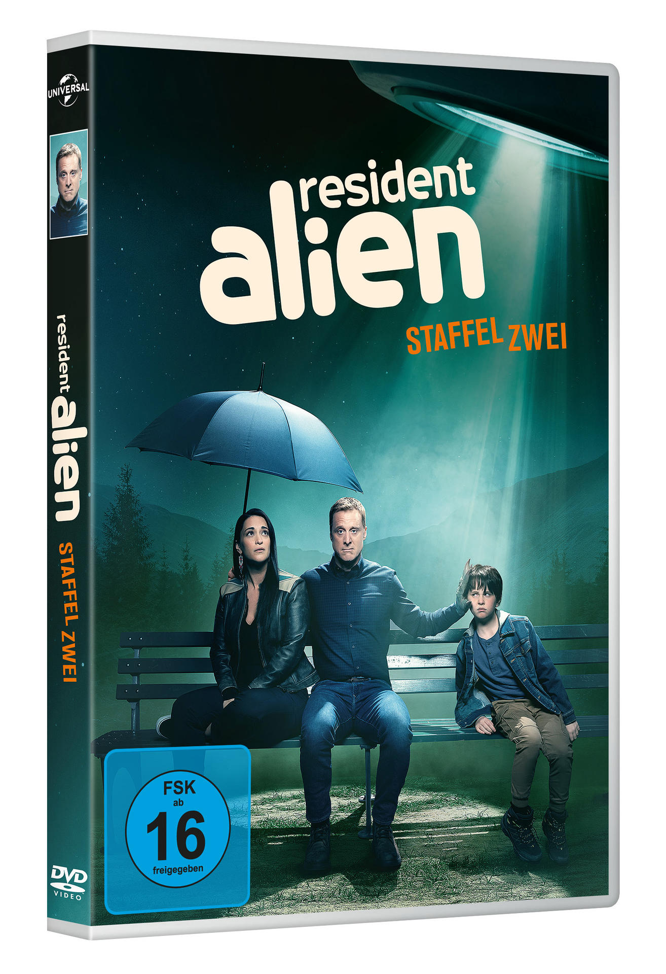 DVD-Hülle von 'Resident Alien' mit Schauspielern, einer Bank und einem Regenschirm in einer Alienszene.