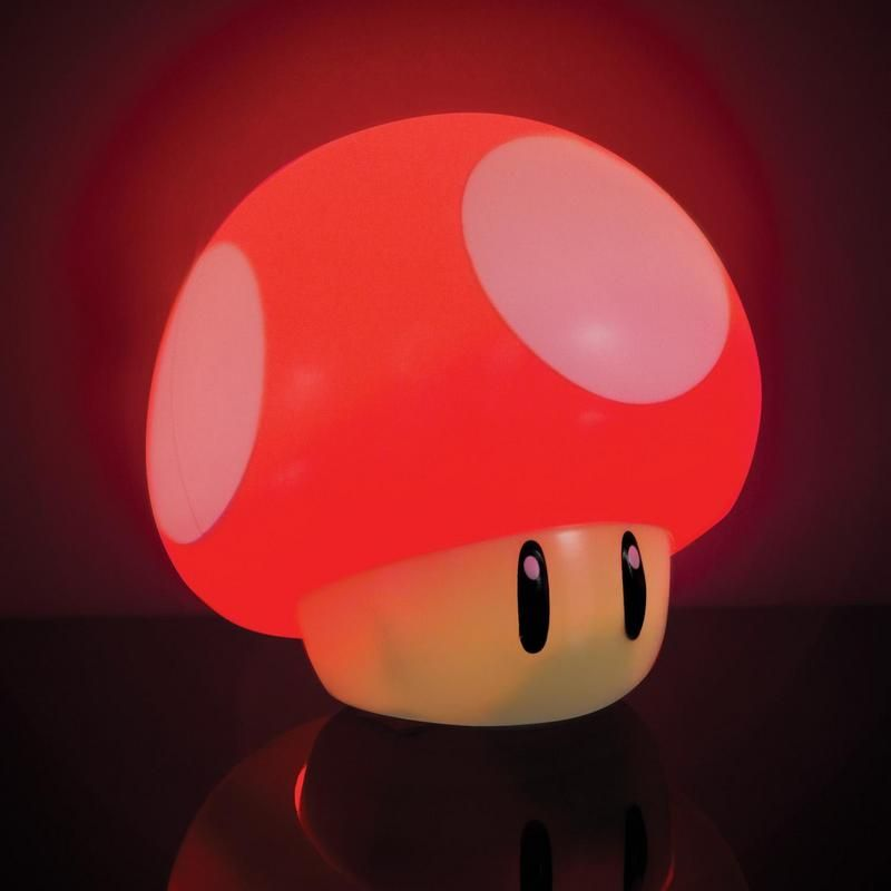 Egy piros-fehér Super Mario gomba lámpa, megvilágítva és világítva.