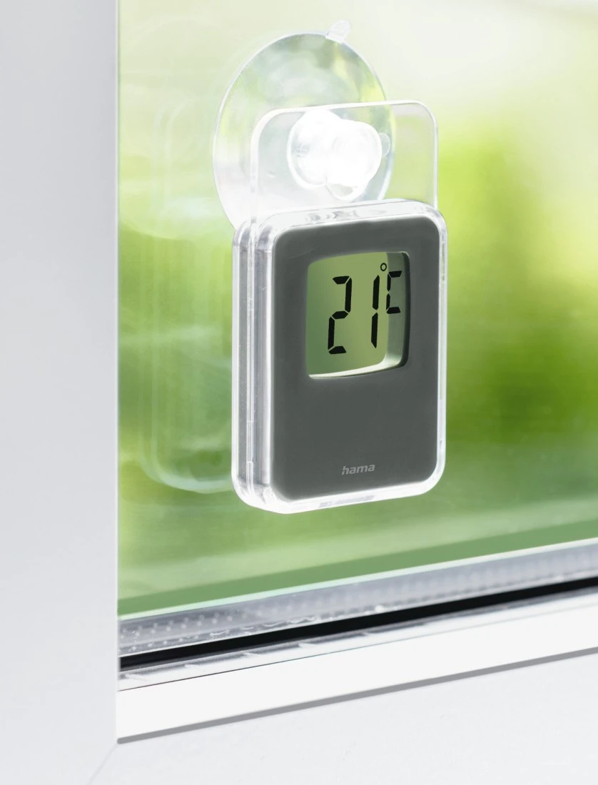 Un thermomètre numérique fixé à une fenêtre avec une ventouse. L'écran affiche 21°F.
